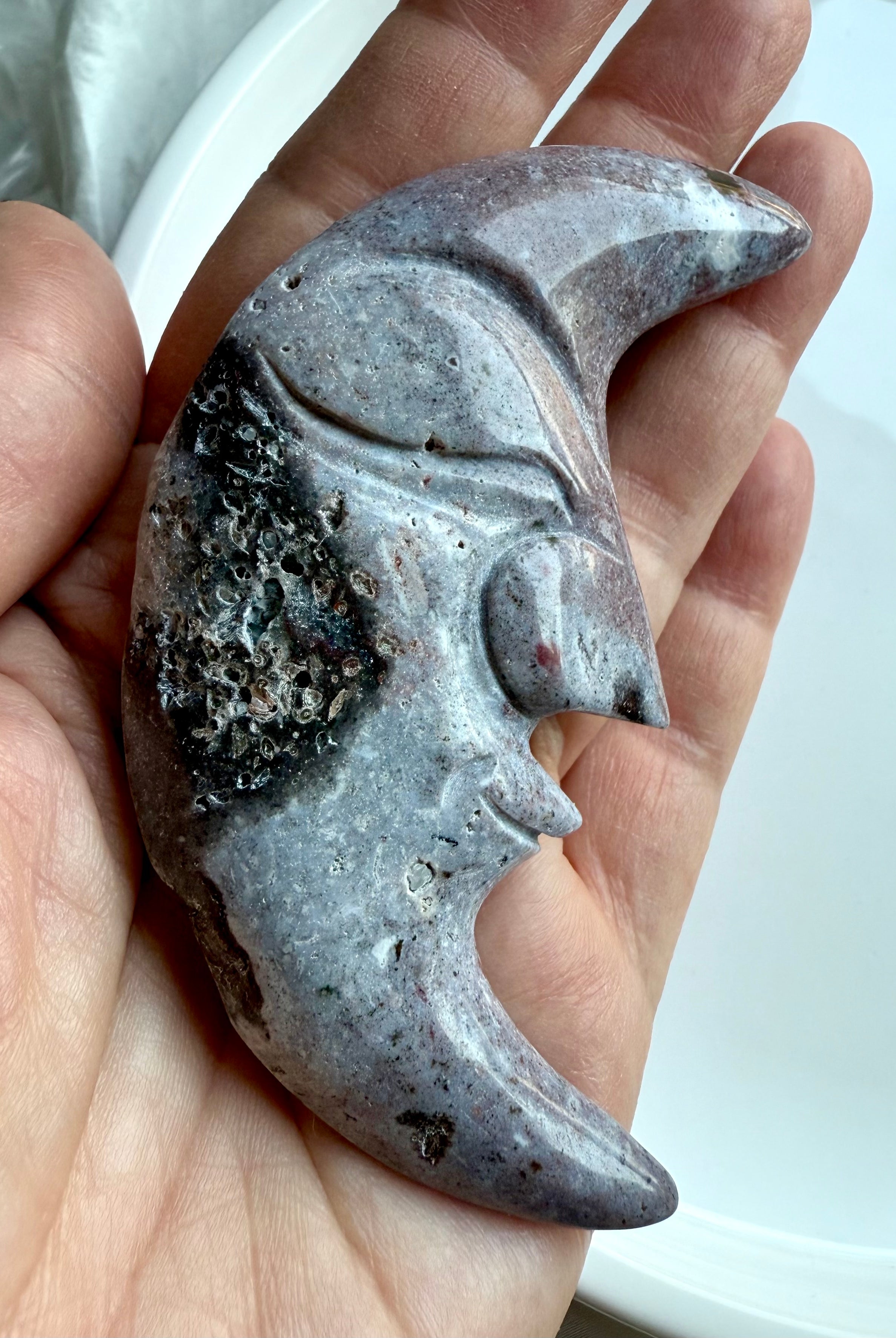 Close-up of Ocean Jasper moon face carving showing sparkling druzy pocket and stone texture.