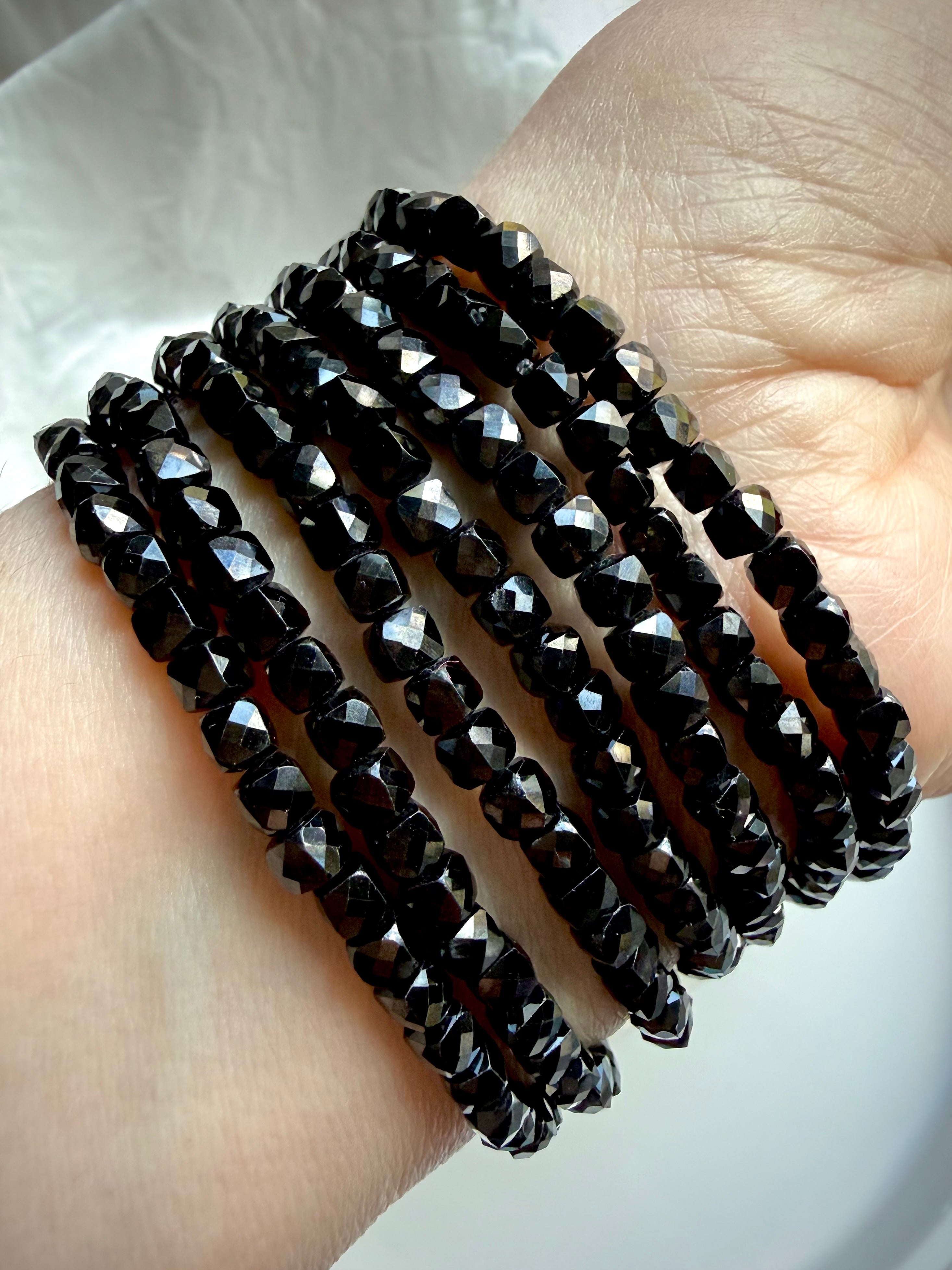 stacked black spinel bracelets on wrist for protection grounding and root chakra energy