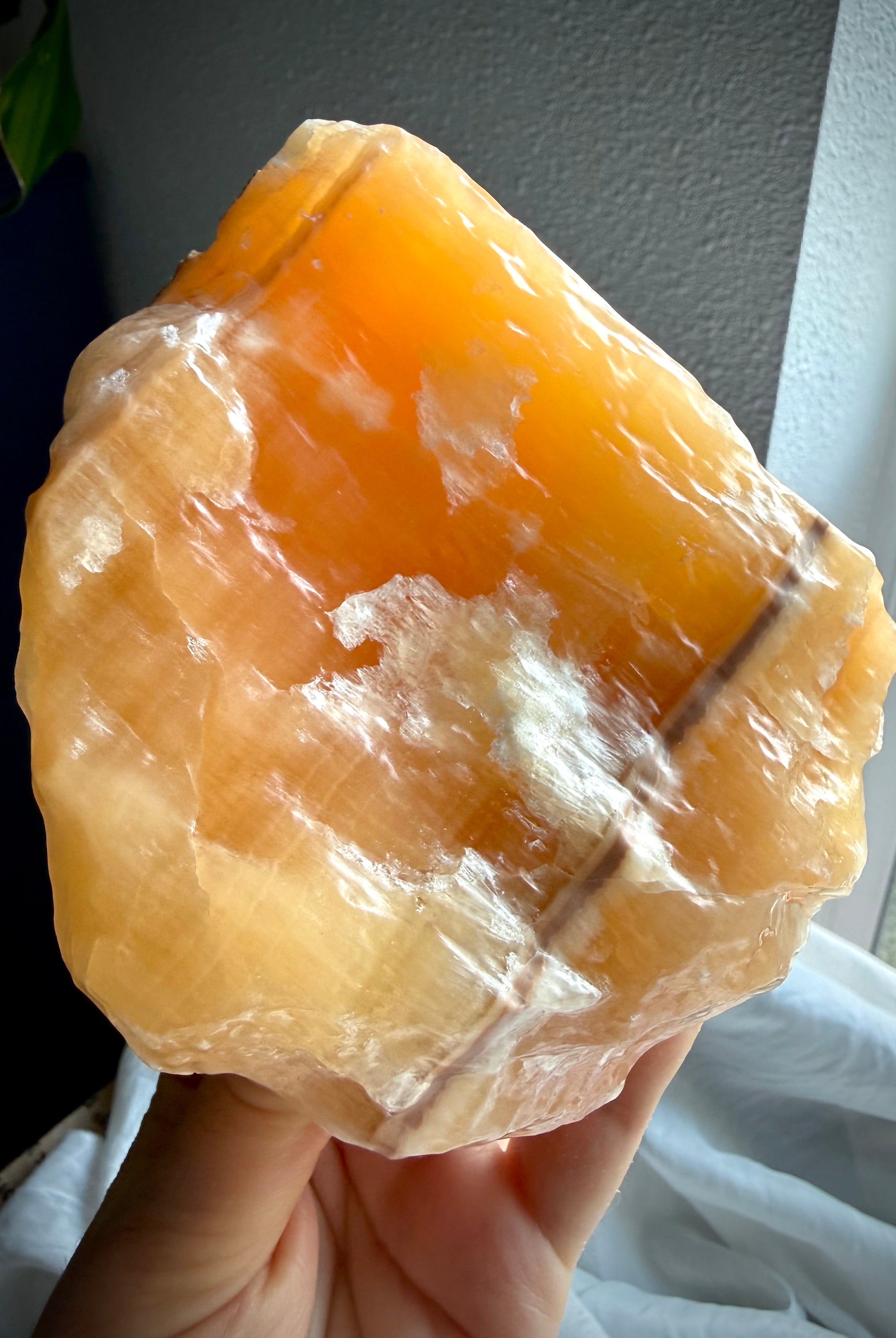 Natural Orange Calcite crystal chunk with glowing translucency, rough formations, and glossy acid-washed finish