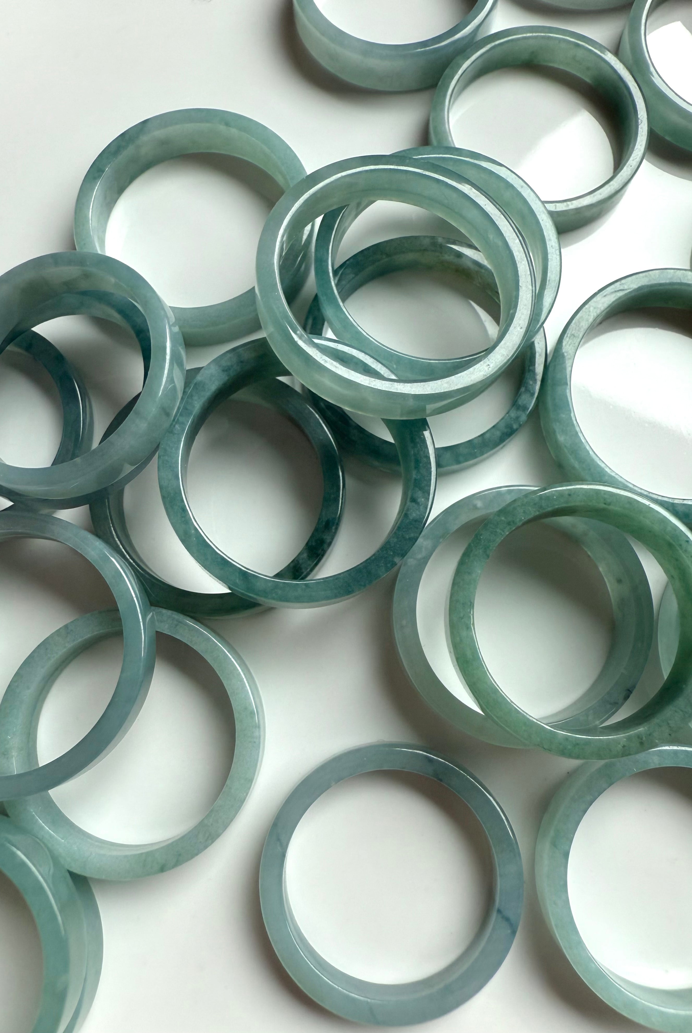 Calming green-blue jadeite crystal rings displayed with peaceful and minimal styling for heart chakra healing