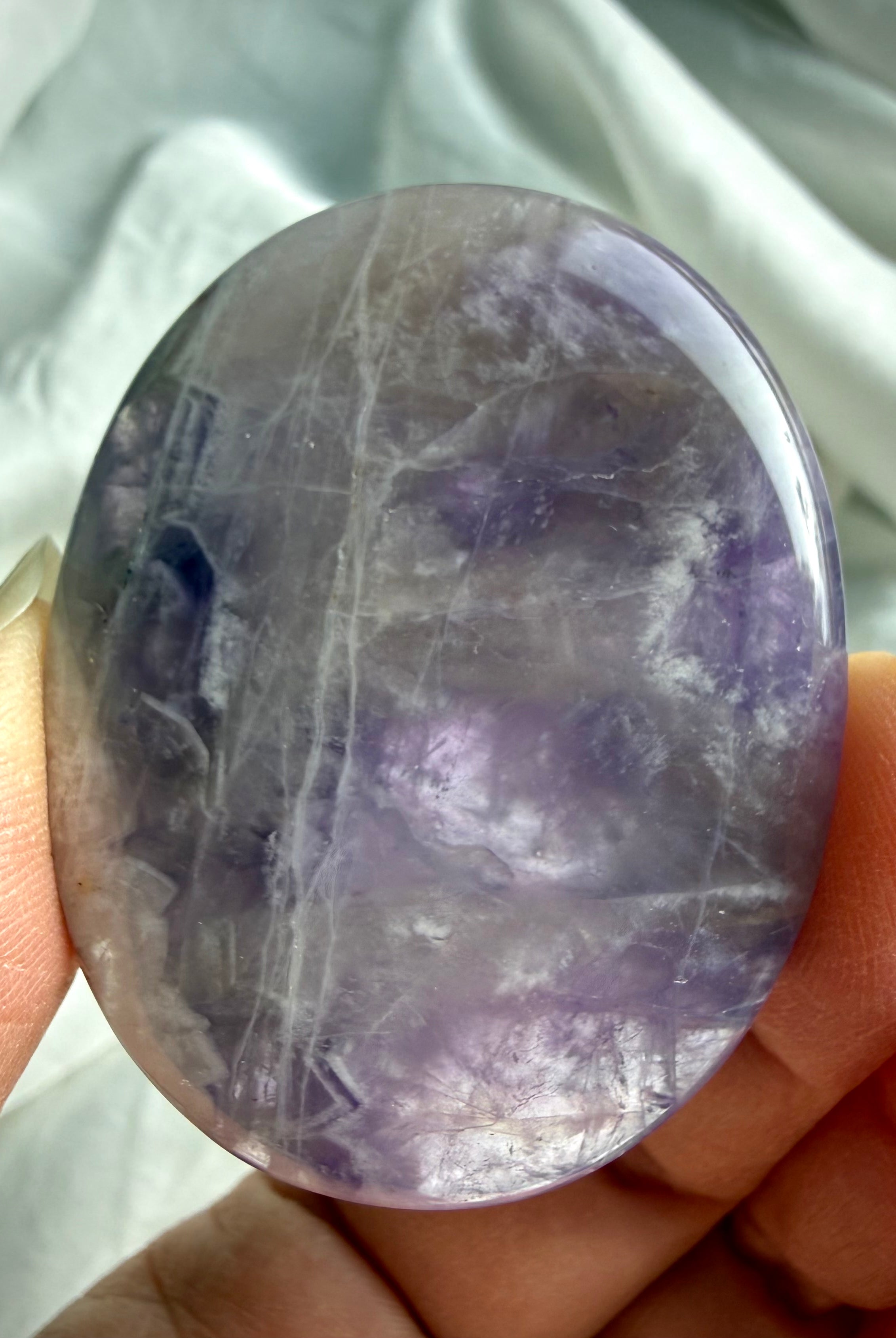 Dream amethyst flat palm stone close up showing natural veining, color variation, and polished flat profile