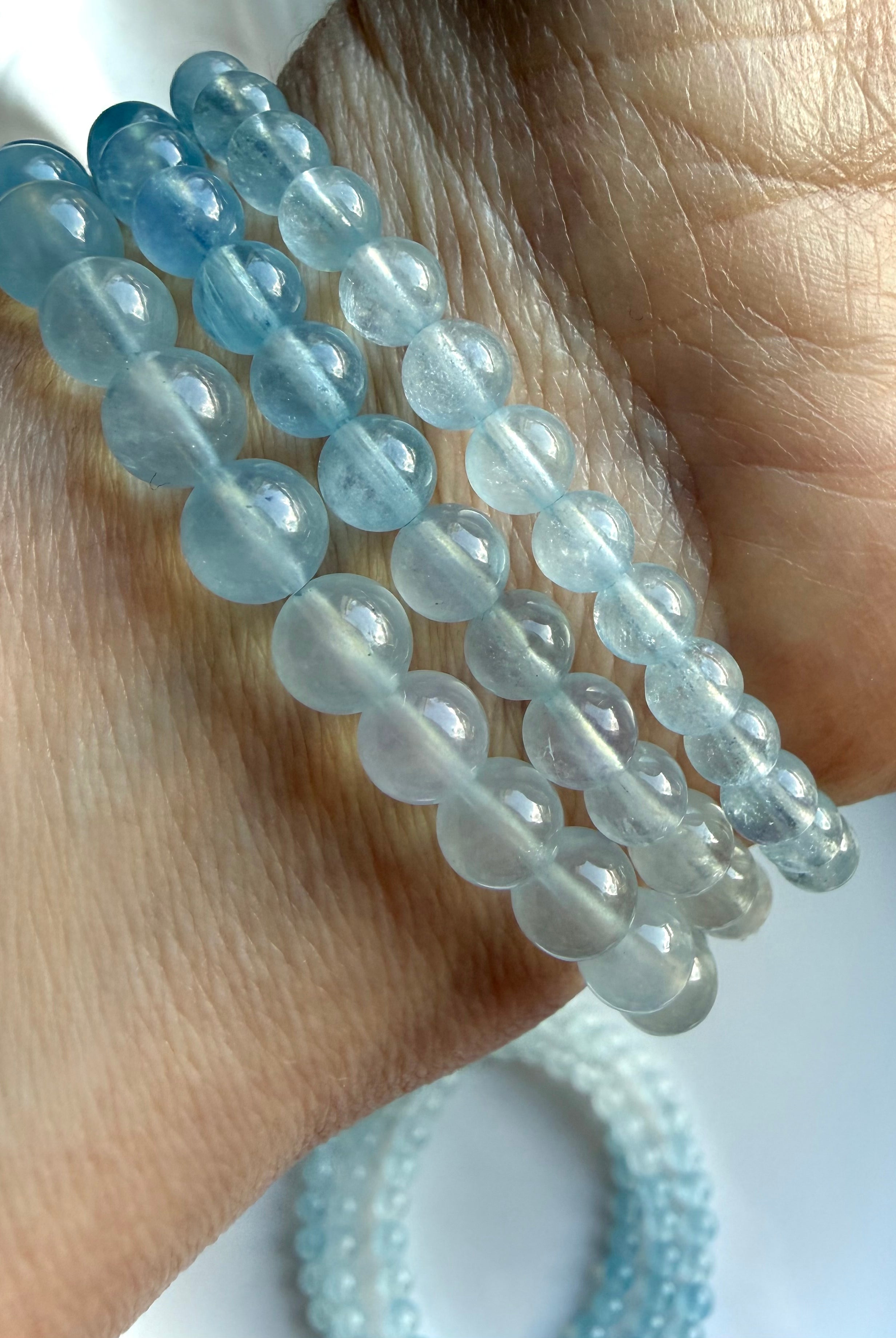 Three Aquamarine ombré crystal bracelets on a wrist – March birthstone and Throat Chakra gemstone jewelry
