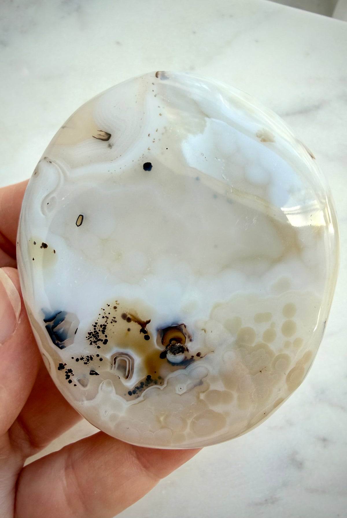 Polished Dendritic Agate crystal with soft cream and gray banding, scattered dark inclusions and organic contours