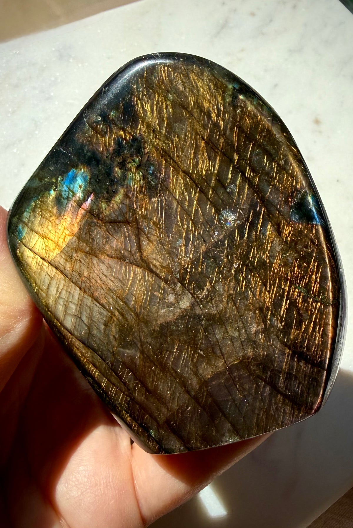 Polished Orange Labradorite freeform showing warm copper flash and angle-dependent color play