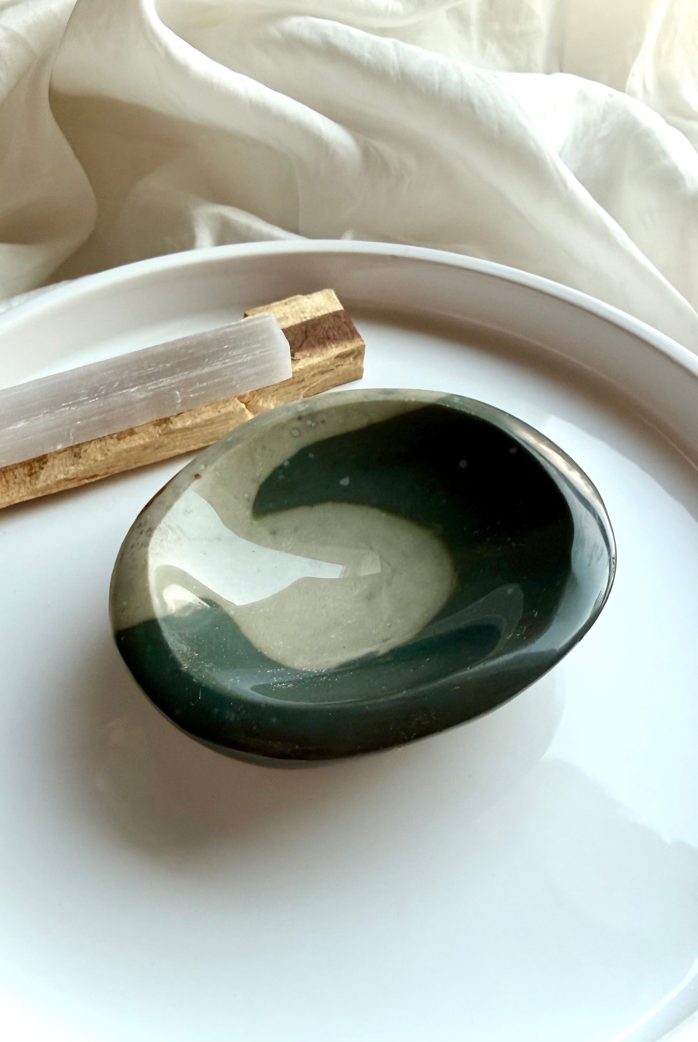 polychrome jasper crystal bowl with teal wave pattern on white tray with selenite and palo santo