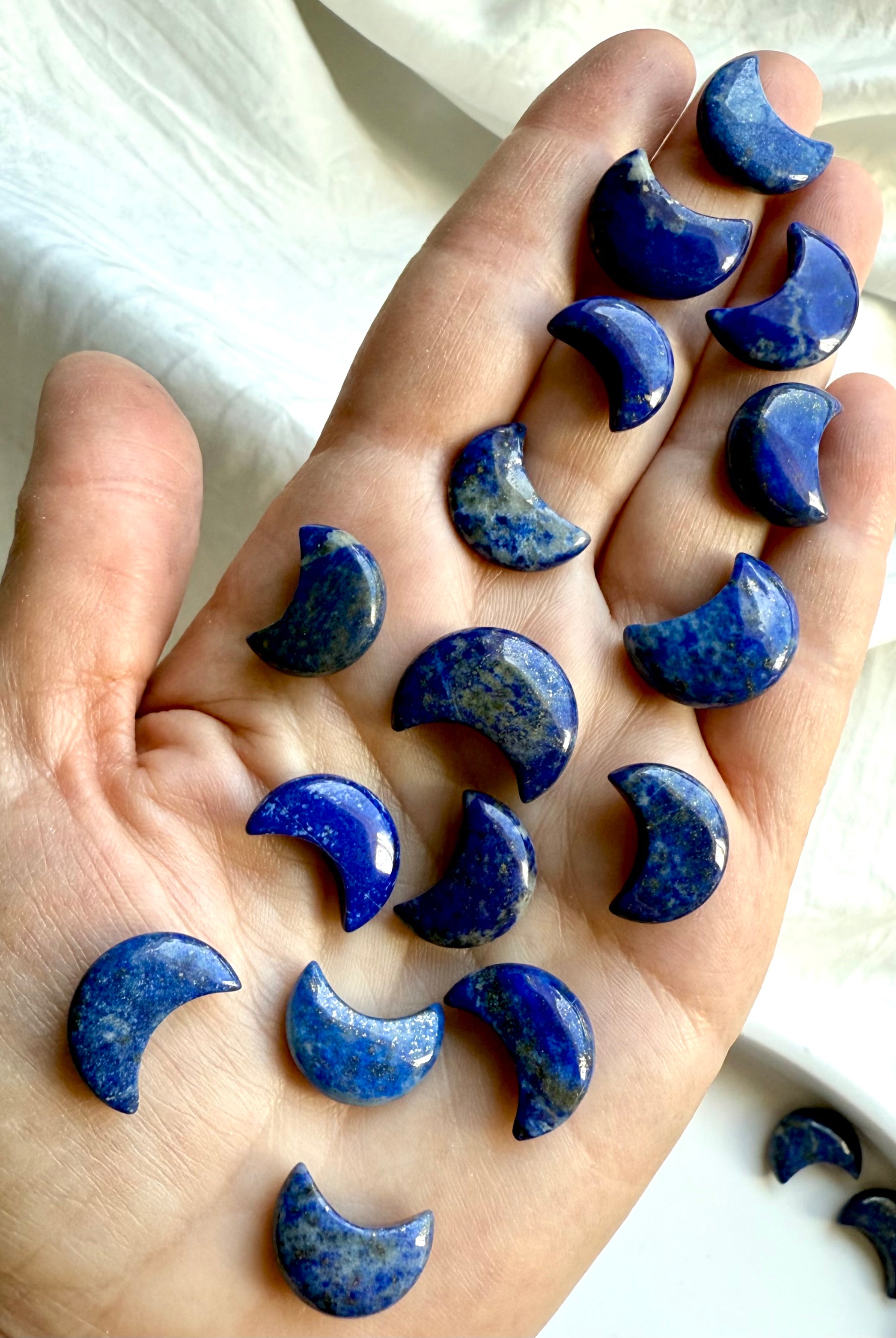 Mini Lapis Lazuli moon carvings a woman's hand for size comparison