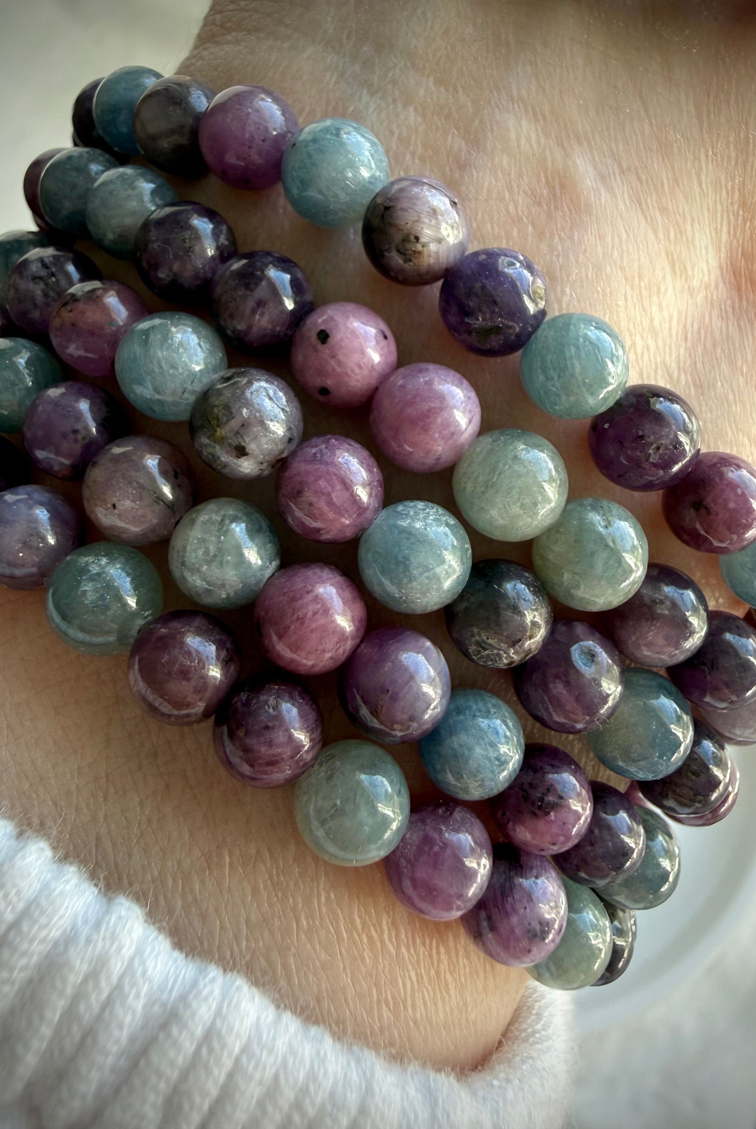 stacked Ruby Sapphire crystal bracelets displaying natural color variation and polished round beads