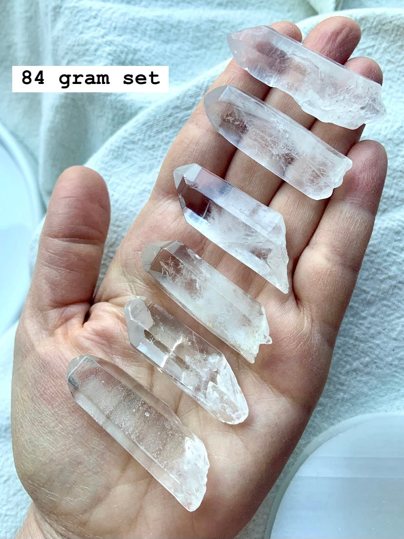 Set of 6 clear quartz points for crystal gridding, shown on hand, marked with size
