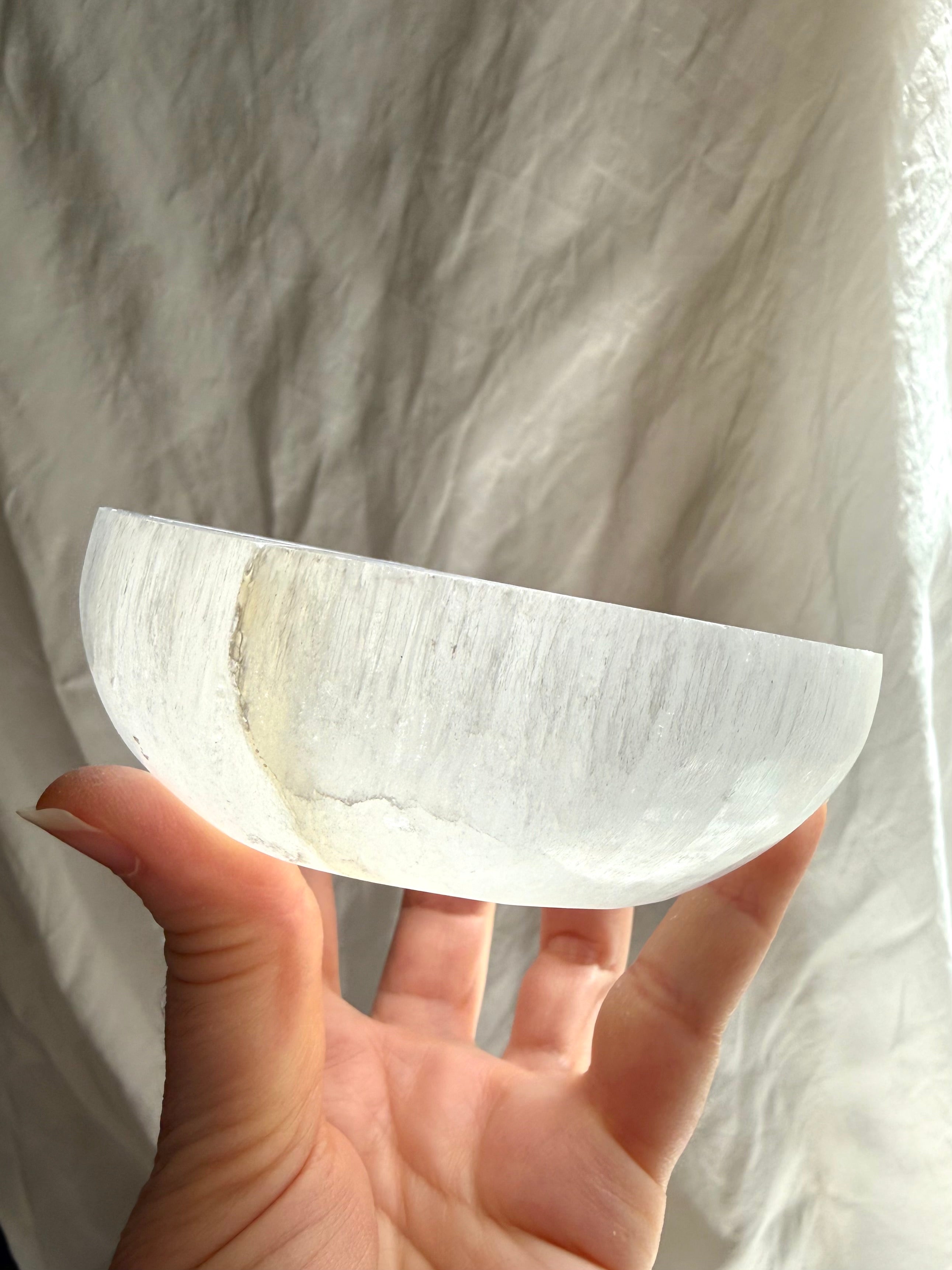 side profile of selenite crystal bowl highlighting thickness and fibrous structure, charging bowl for altar decor