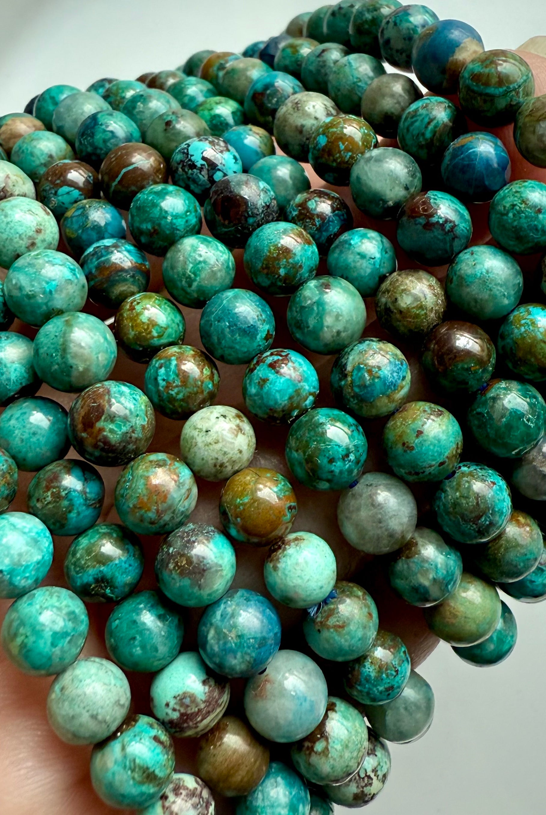 Stack of Chrysocolla Shattuckite bracelets showing earthy turquoise, blue, and brown gemstone beads for wisdom and communication