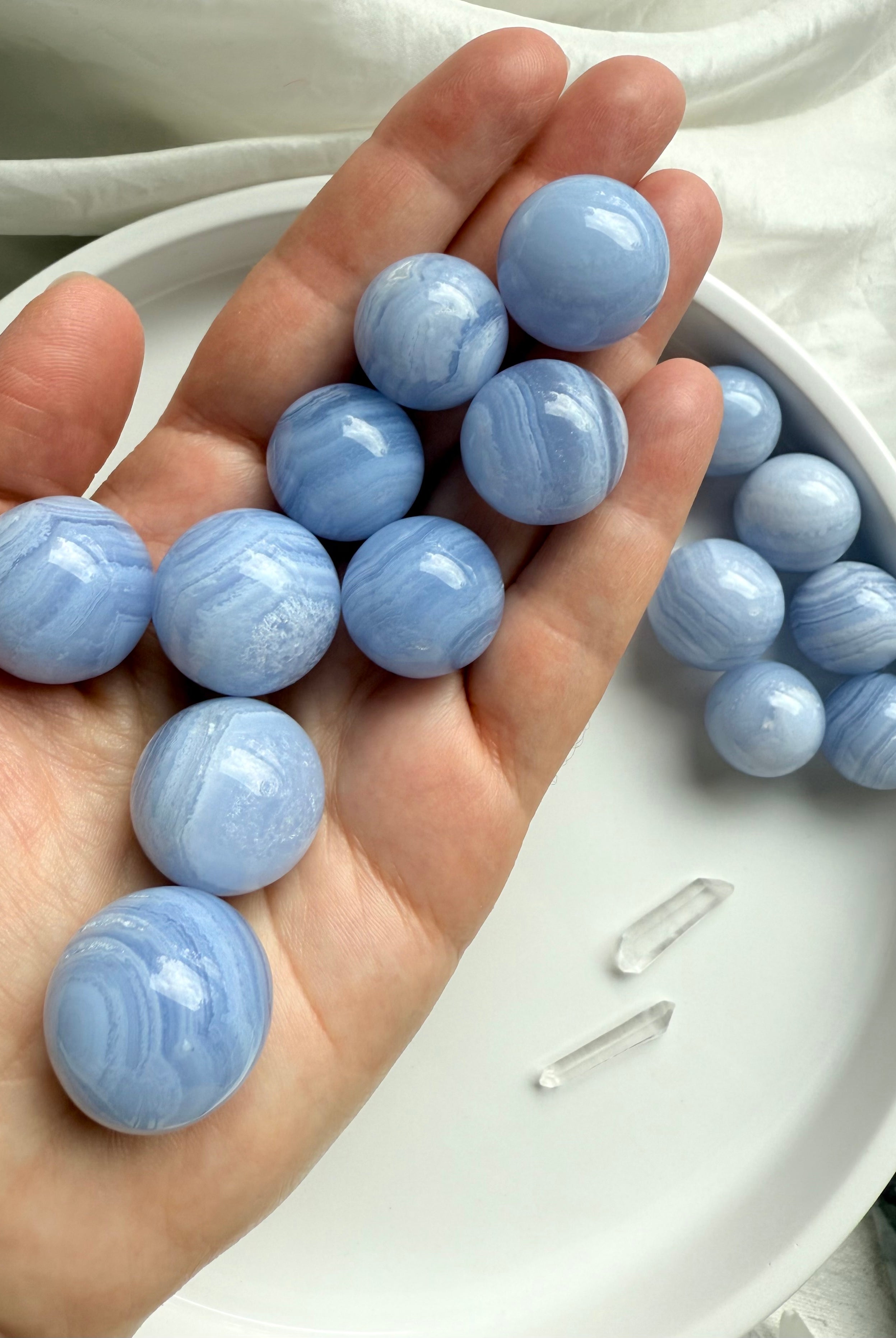 High quality mini Blue Lace Agate Spheres shown on my hand for scale