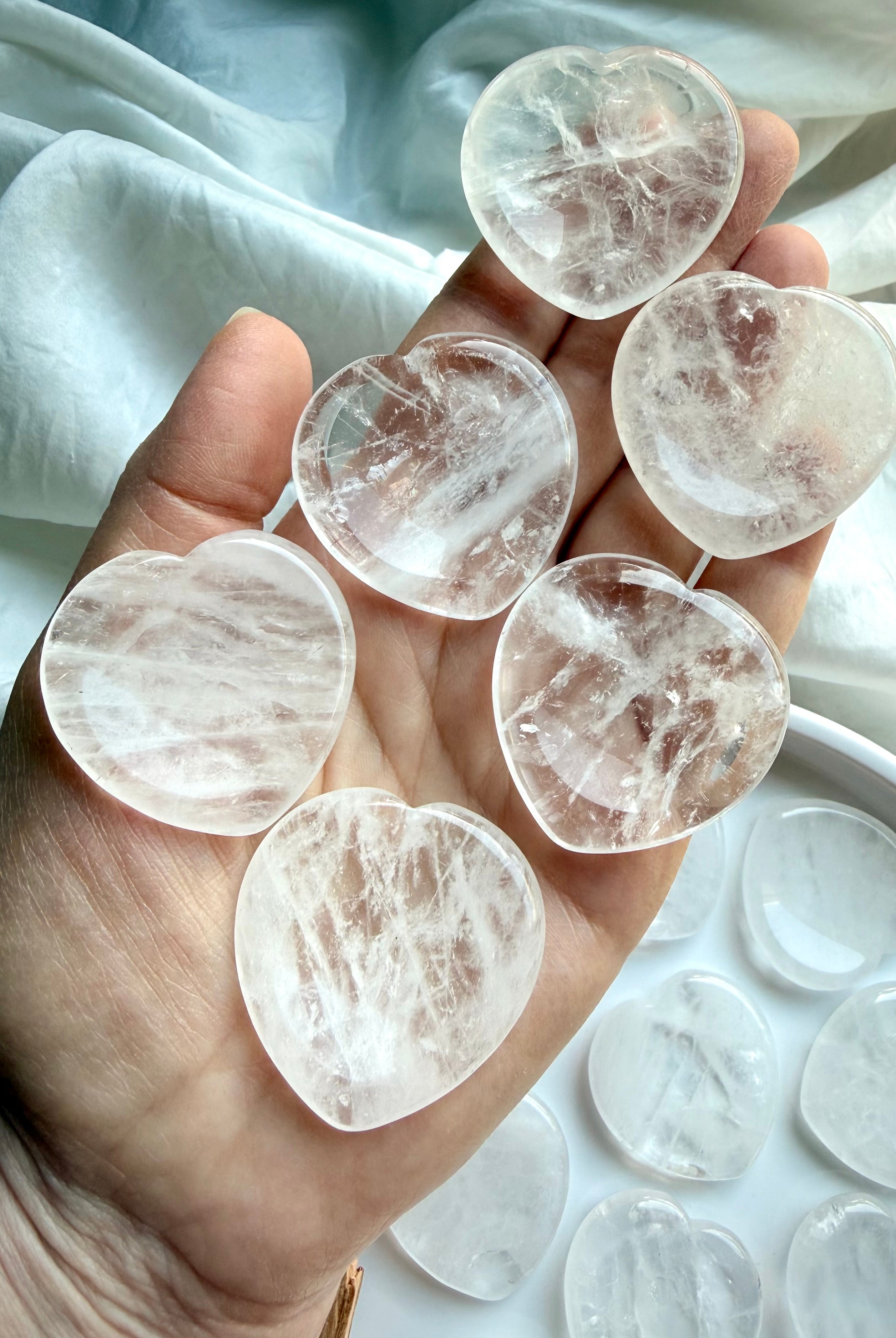 clear quartz hearts in hand for energy amplification clarity and calming support