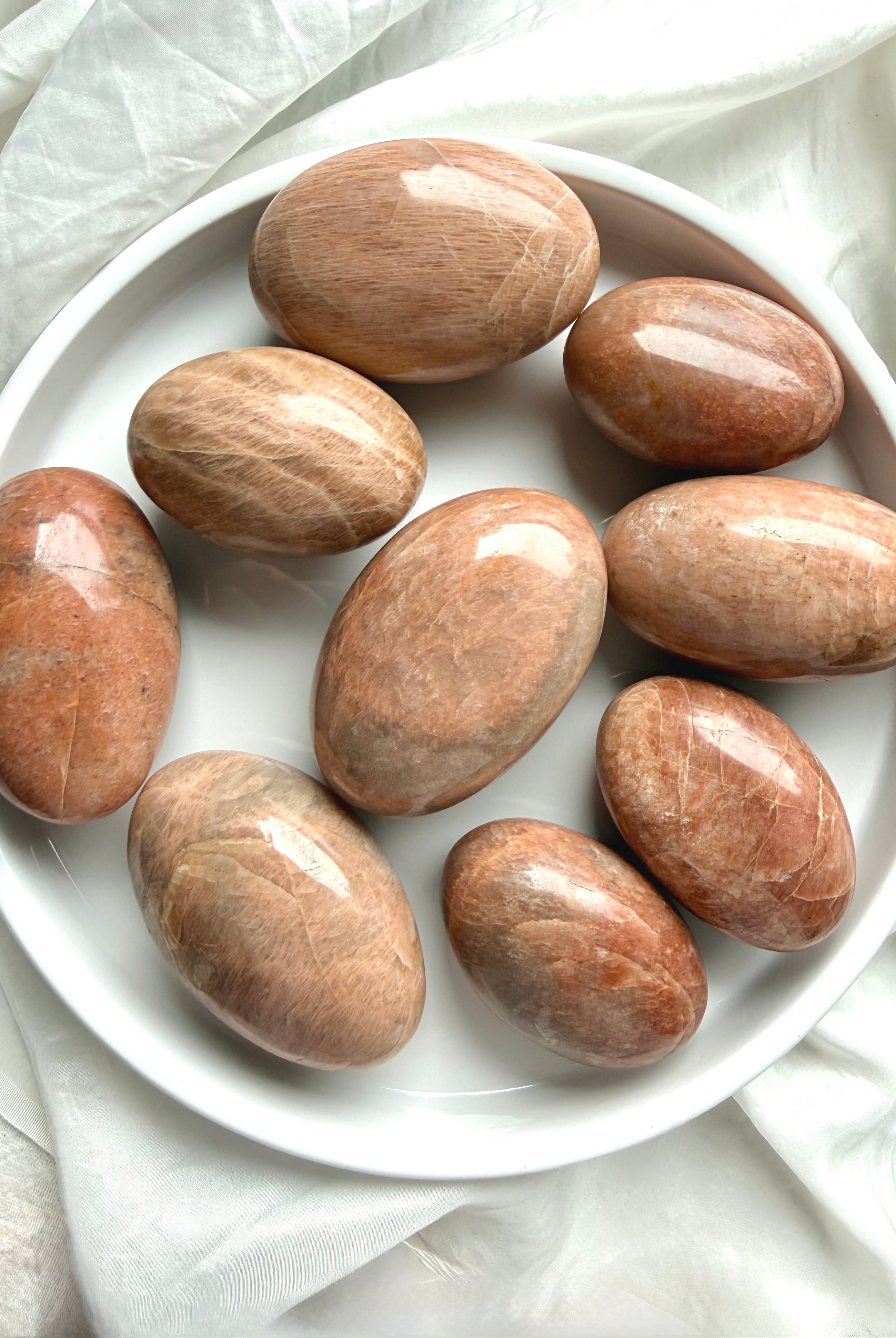 Large Peach Moonstone palm stones with glossy polished finish and natural peach orange coloring