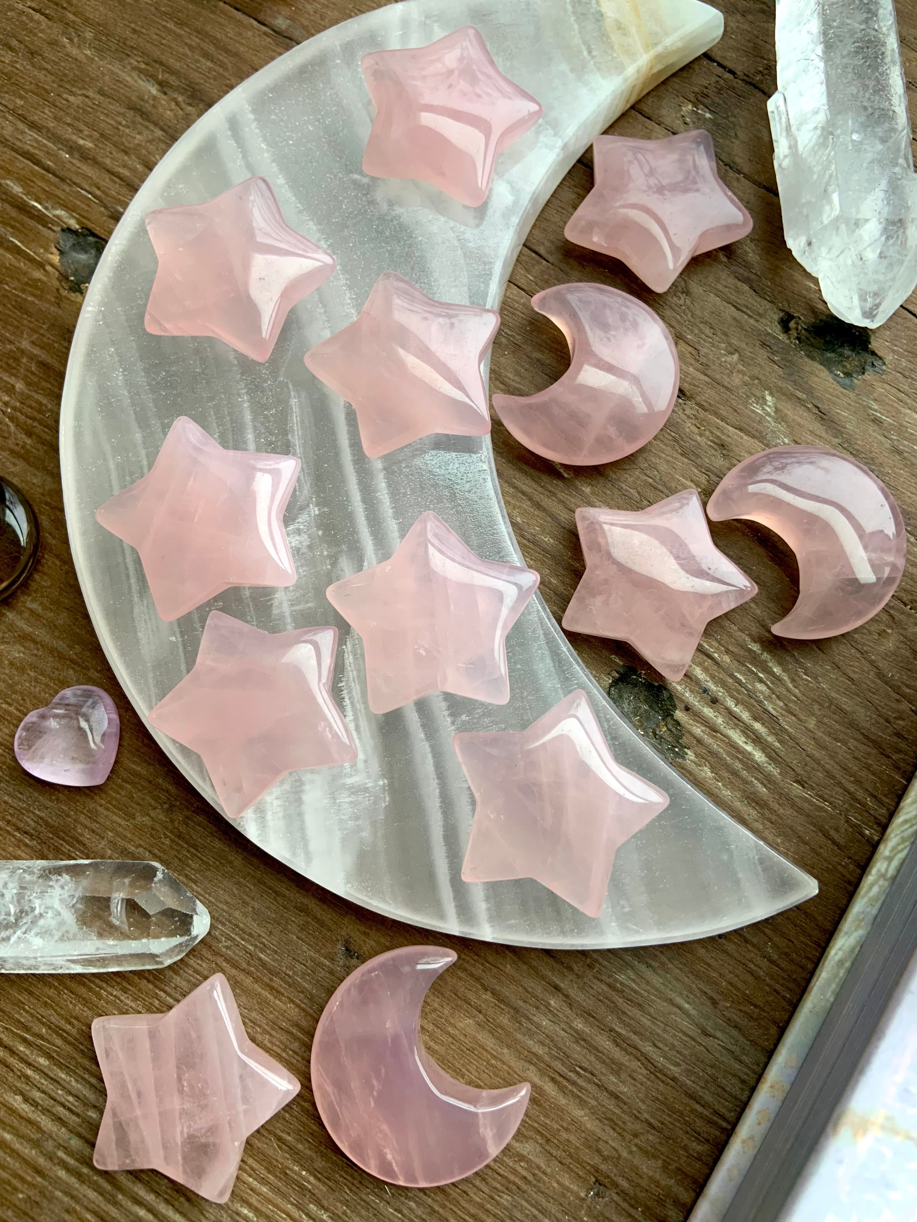 Angled view of rose quartz crystal moons and stars on a white onyx moon plate with quartz crystals