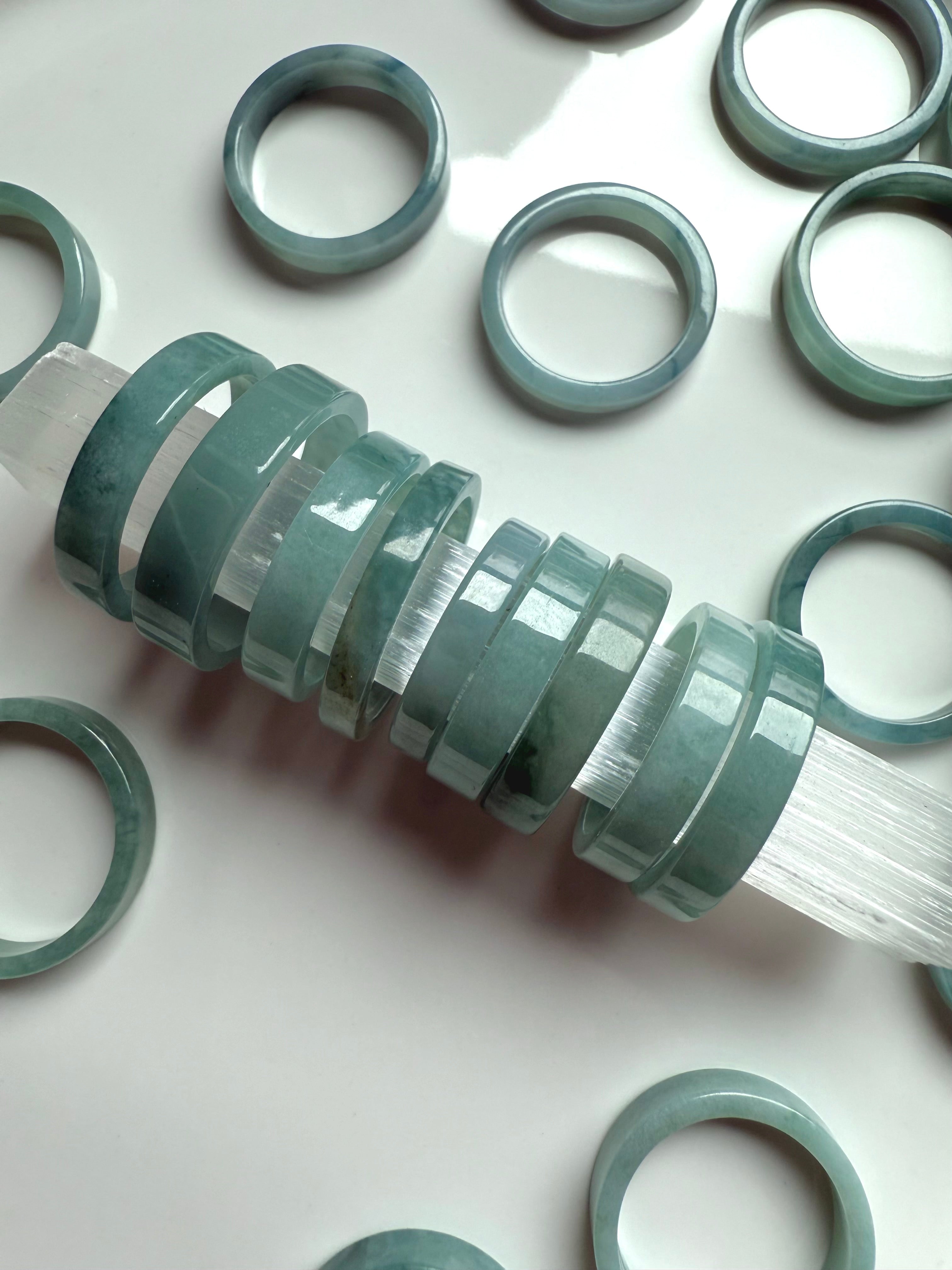 Blue Water Jade crystal rings lined up on a selenite wand for cleansing and presentation