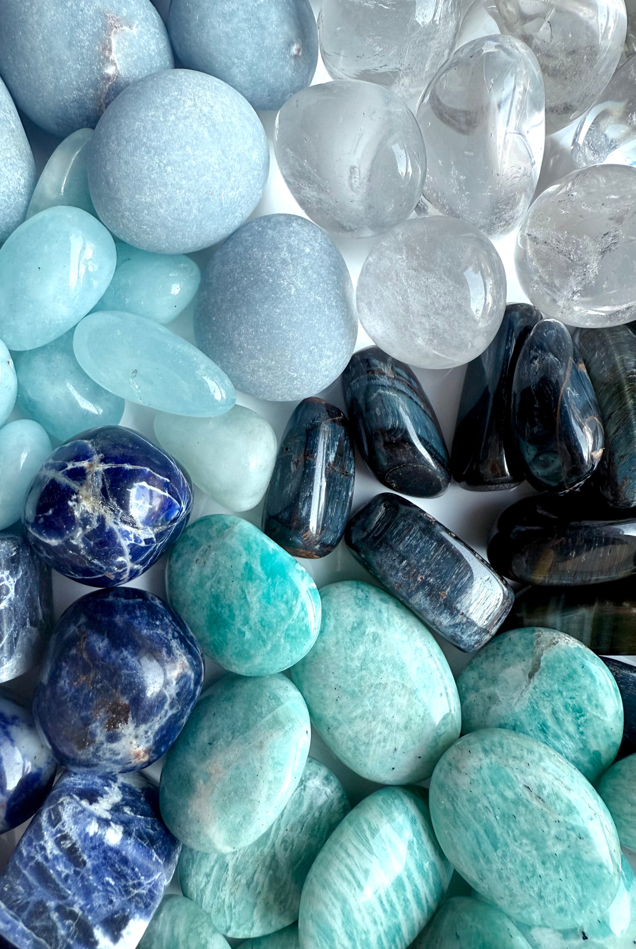 Close-up of throat chakra crystal set showing Angelite, Sodalite, Amazonite, Aquamarine, Blue Tiger’s Eye, and Clear Quartz