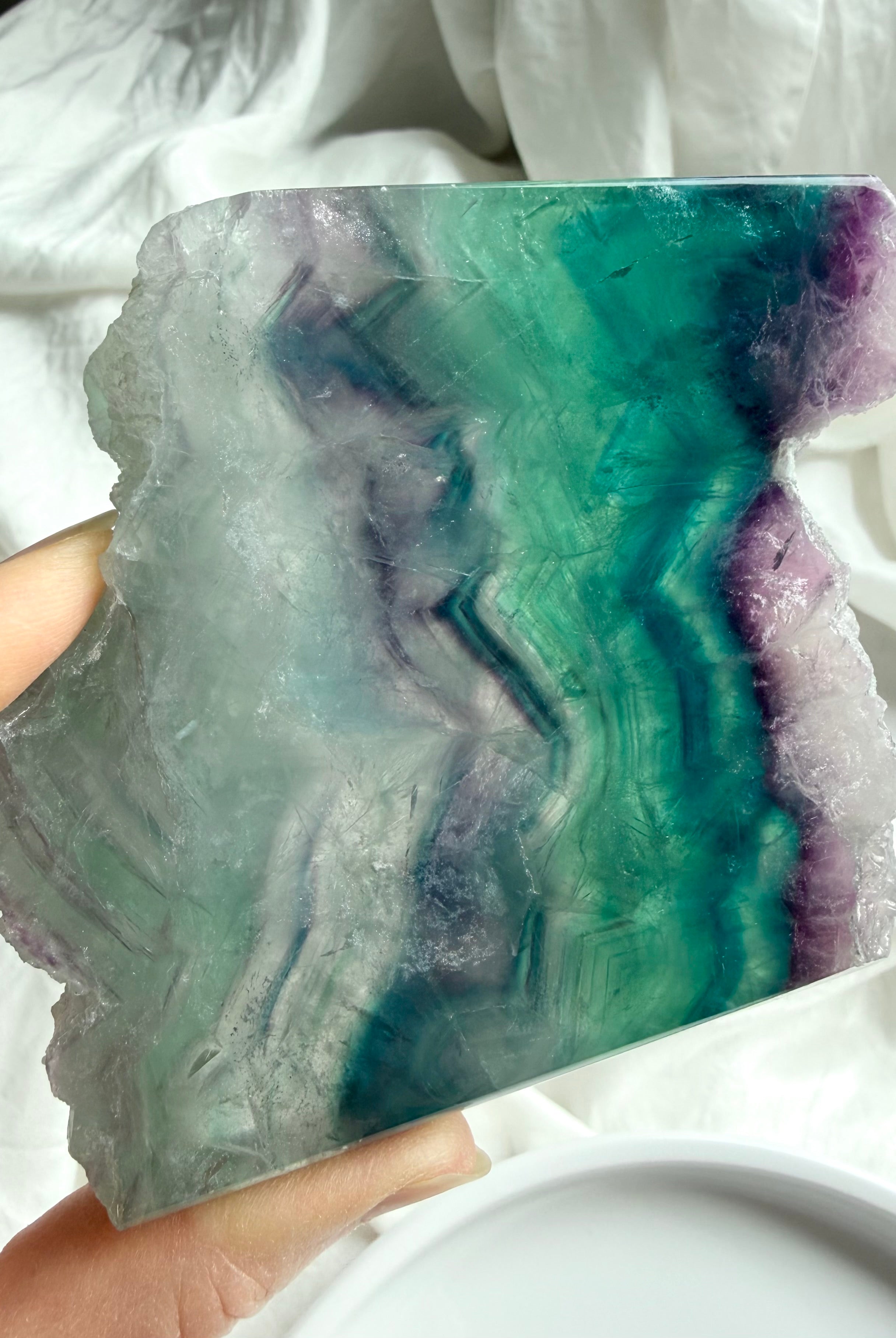 Close-up of natural fluorite slab showing layered color zoning and polished crystal surface