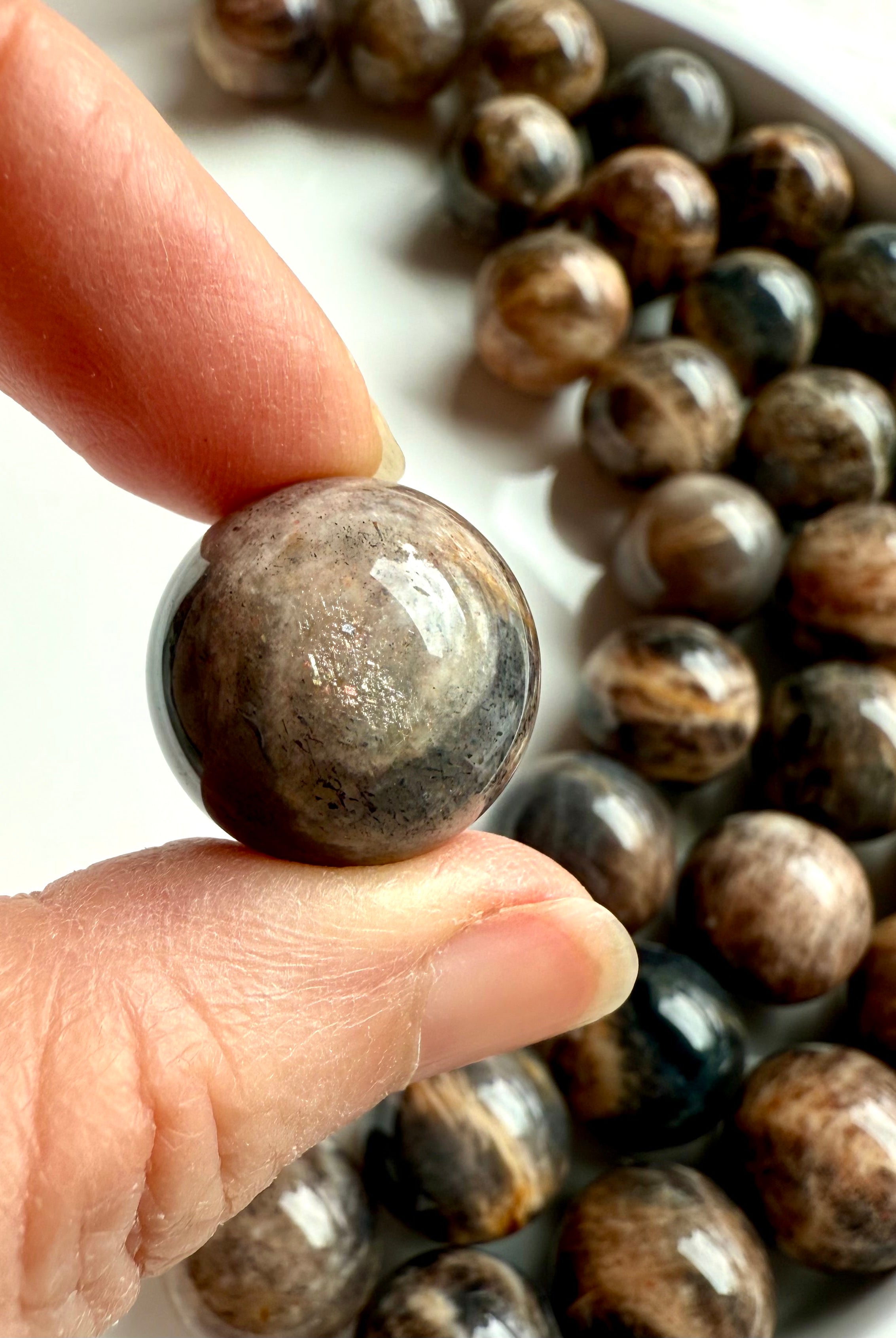Closeup of Mini Black Moonstone sphere showing lattice sunstone inclusions and golden shimmer