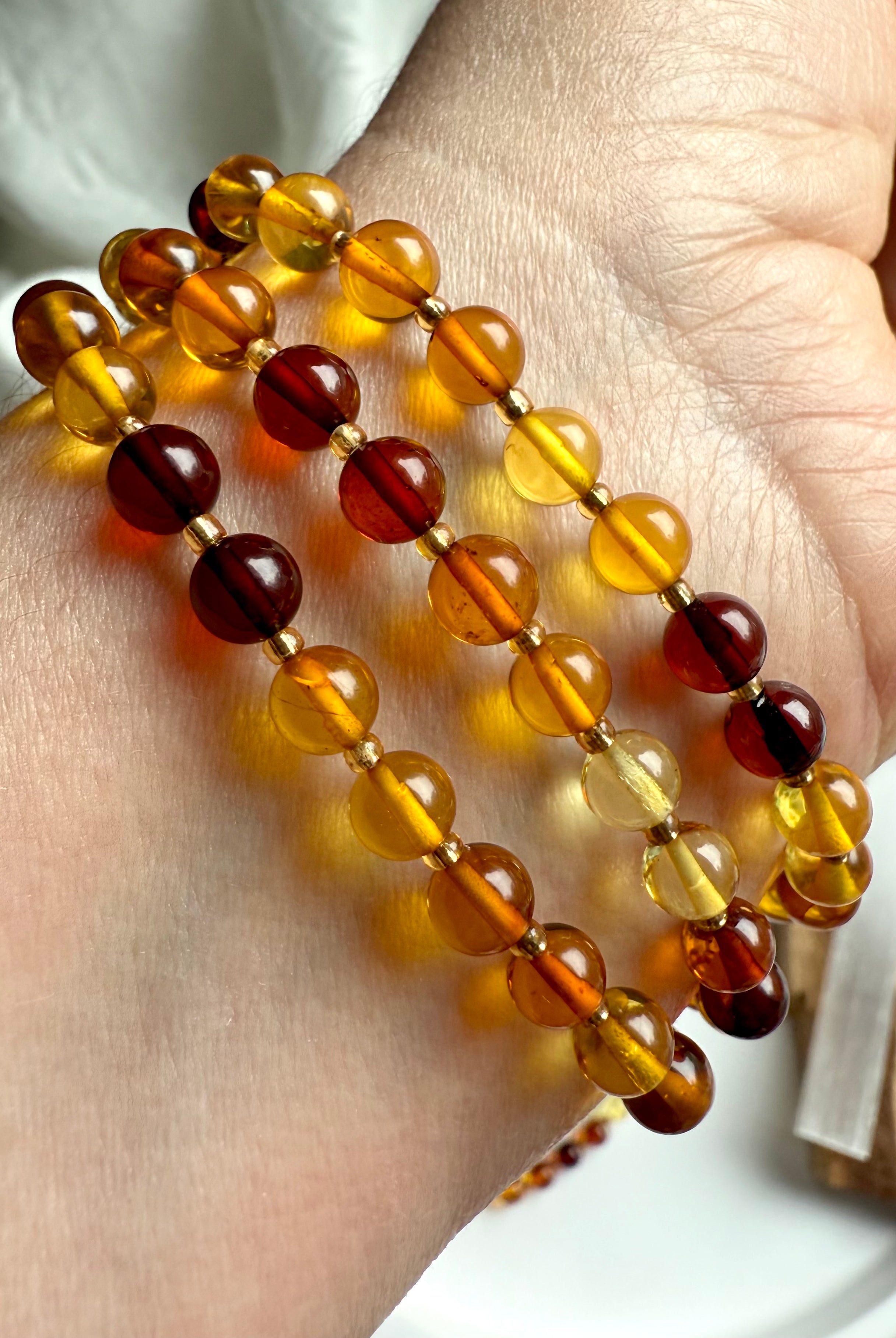Stack of three polished golden amber bead bracelets – warm healing crystal for solar plexus chakra support