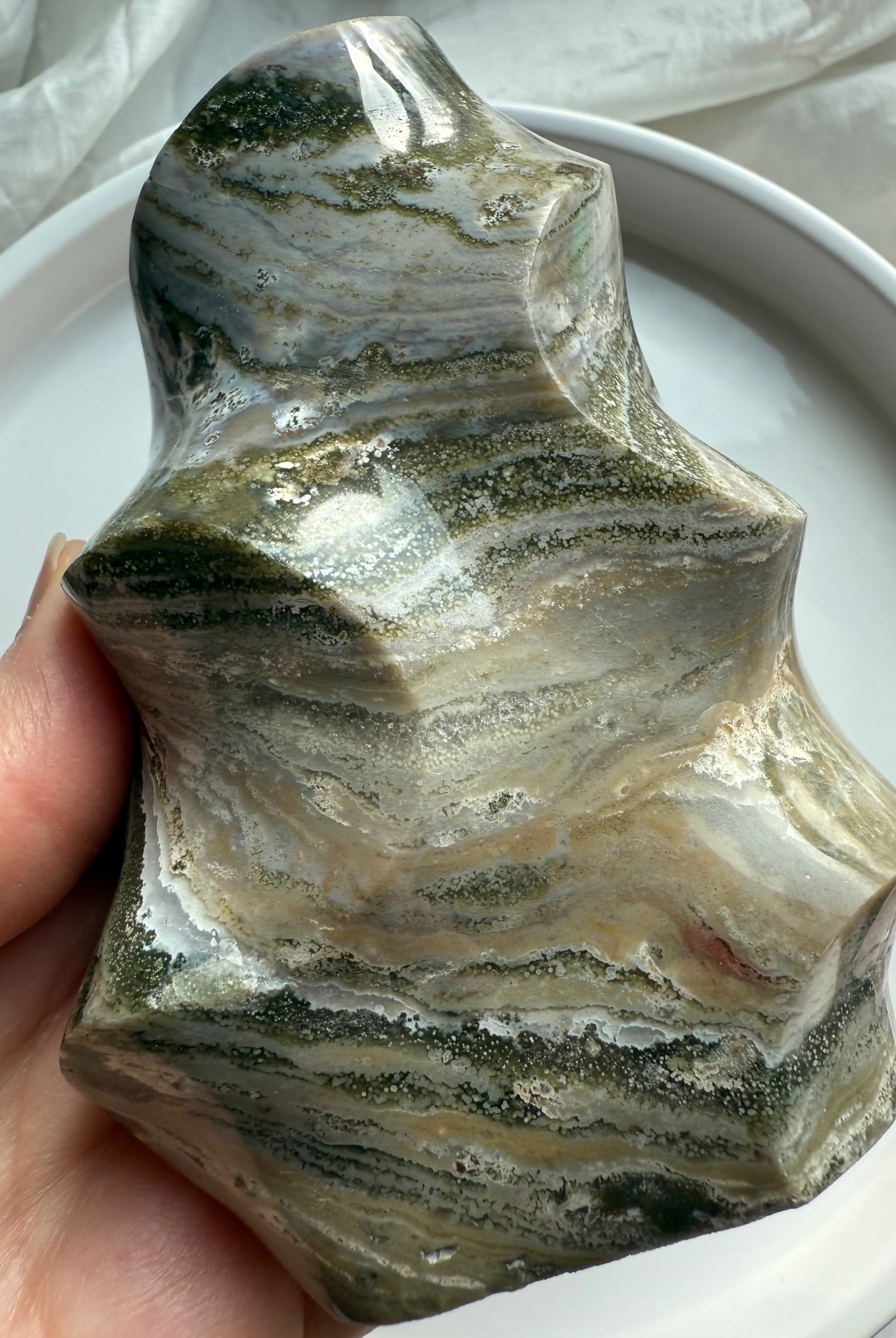 Green Ocean Jasper flame carving with swirling mossy bands and polished freeform shape, grounding Earth-energy crystal.