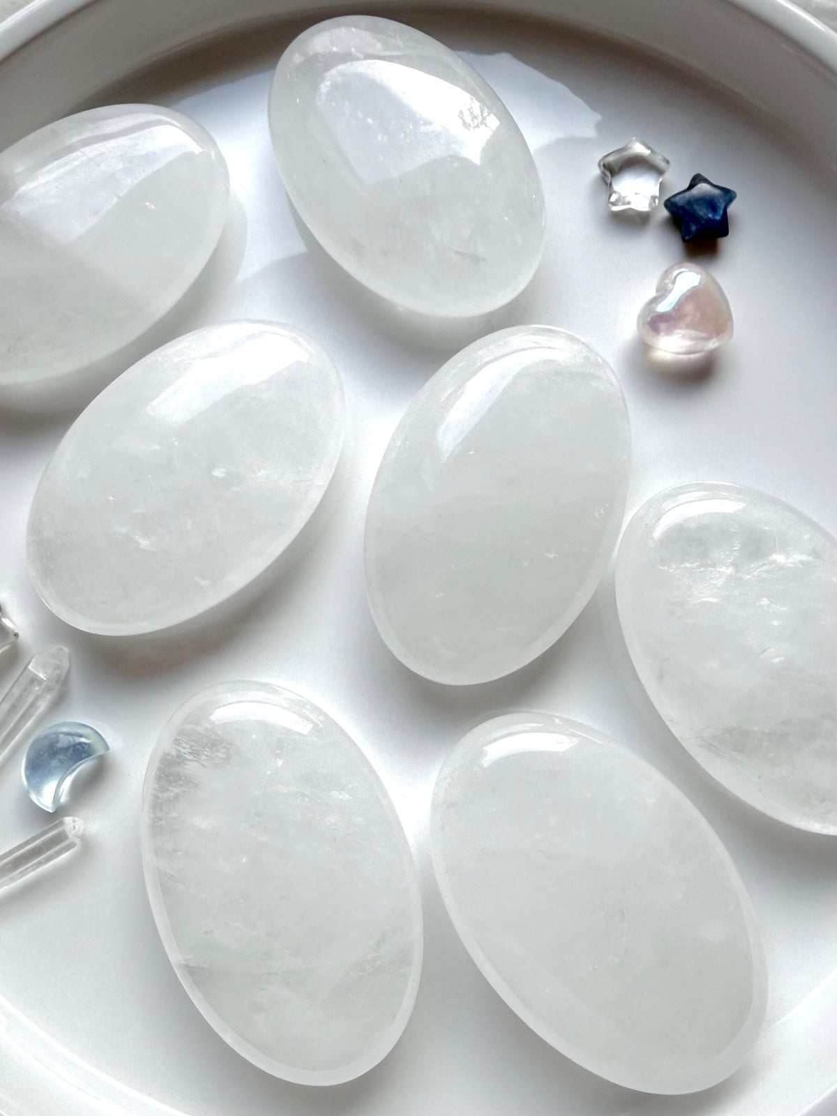 Clear Quartz palm stones with translucent clarity, white internal veils and luminous crystalline patterns for meditation