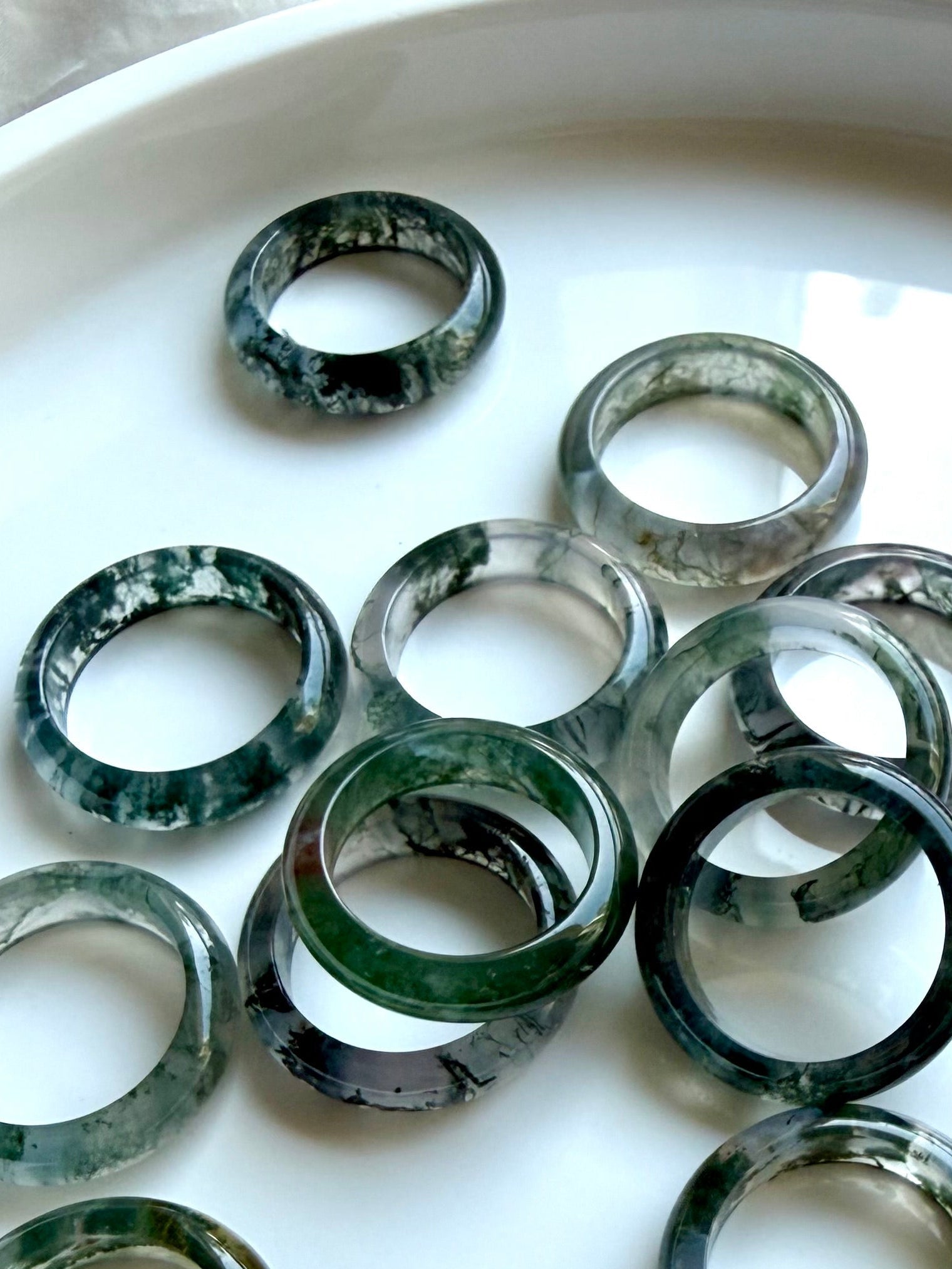 moss agate band rings with translucent green dendritic patterns on marble, crystal rings for grounding growth and heart chakra healing