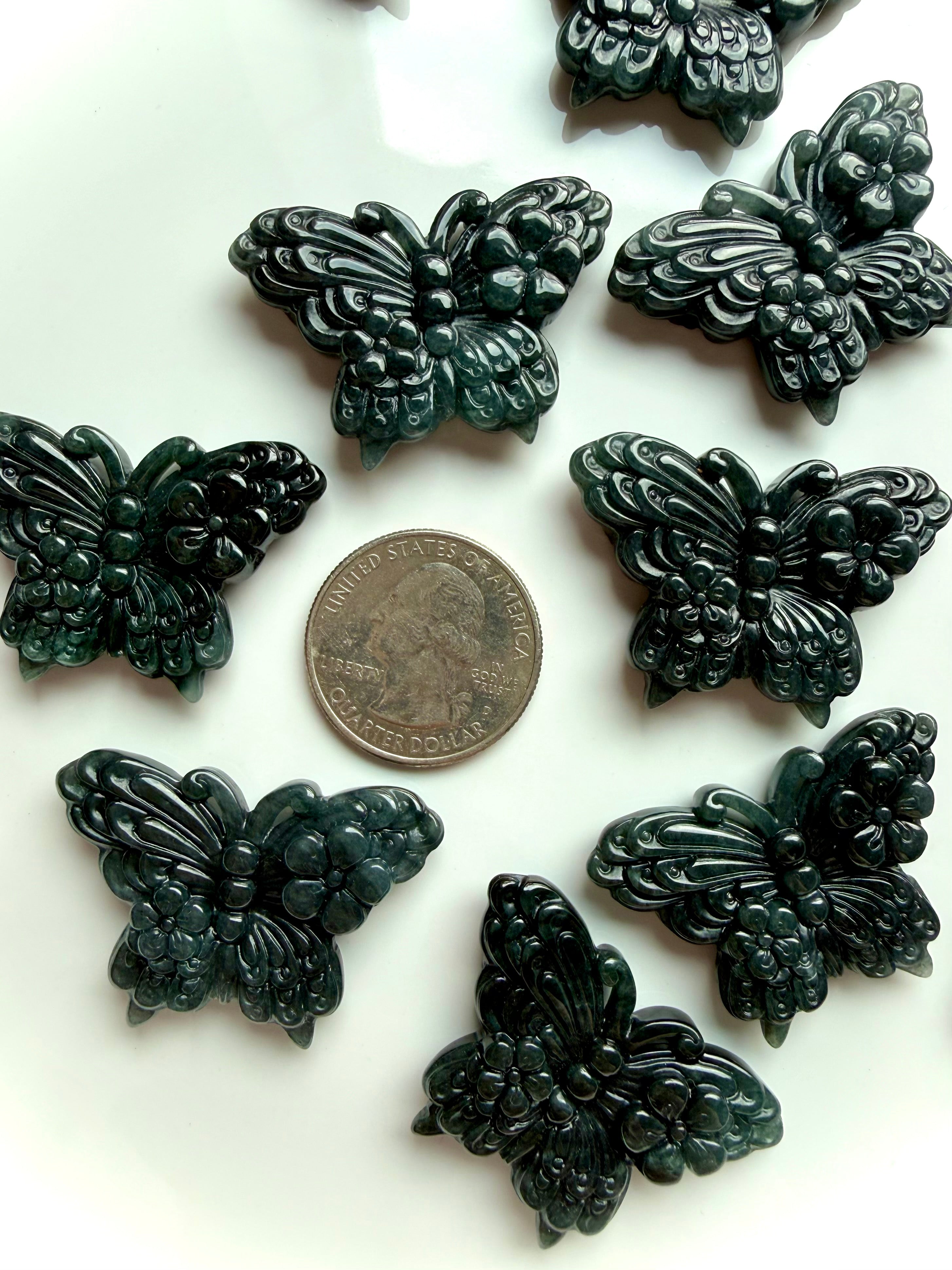 Wuji jade butterfly carvings shown with a US quarter for size reference in Guatemalan jade