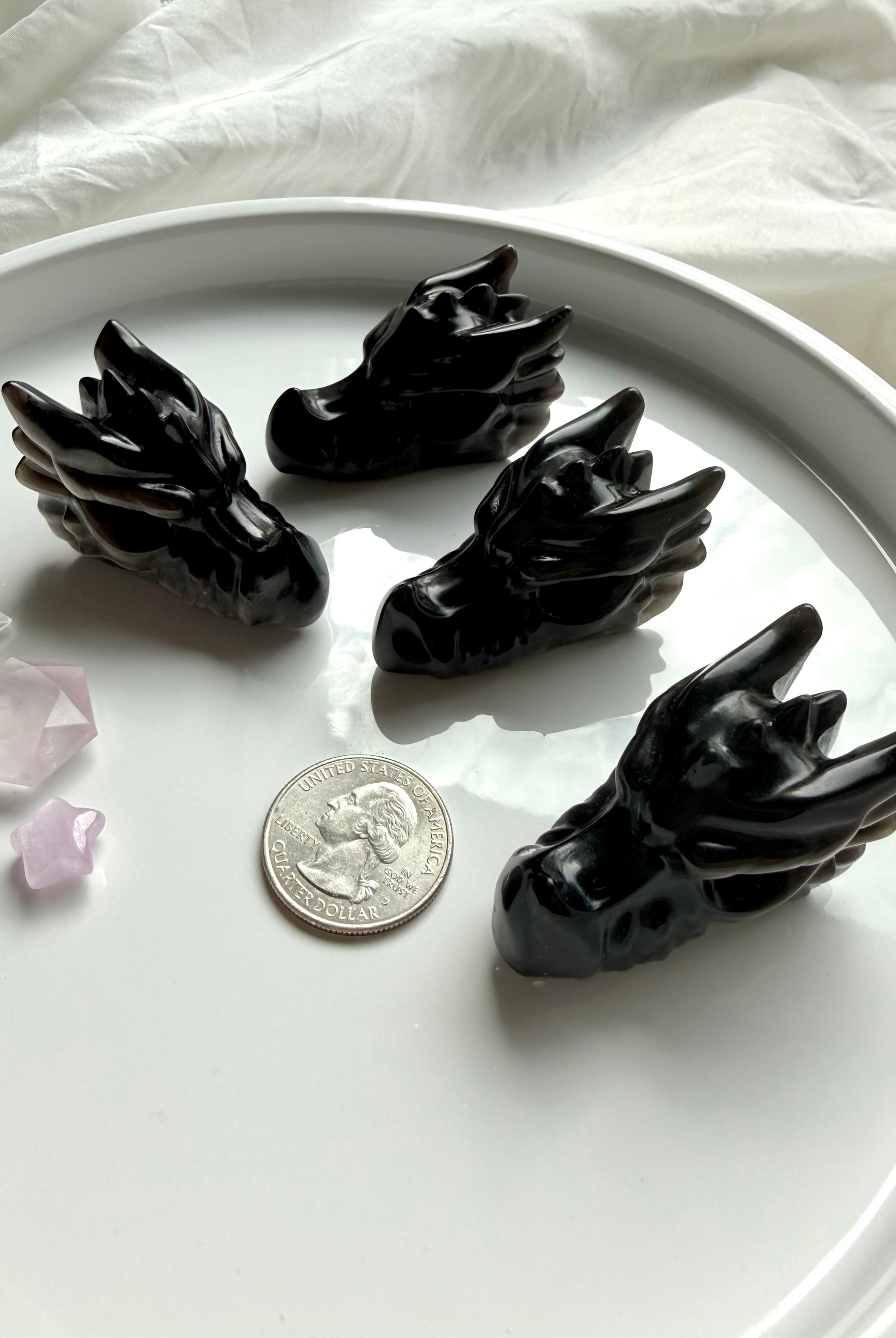 small silver sheen obsidian dragon carvings styled with a US quarter for scale, protective crystals for grounding and psychic protection