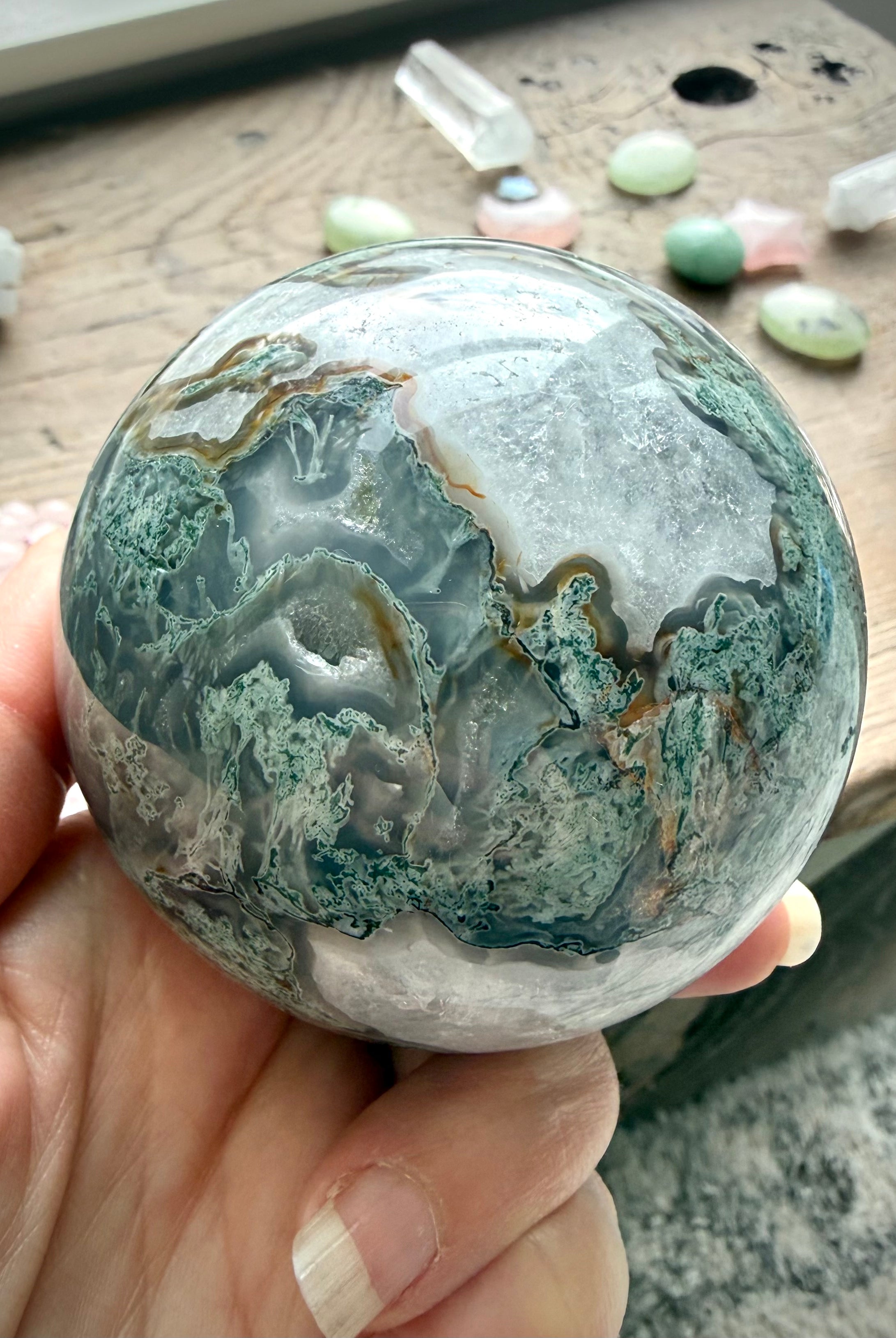 Moss Agate sphere close up showing Quartz veining, translucent areas, and unique mineral patterns