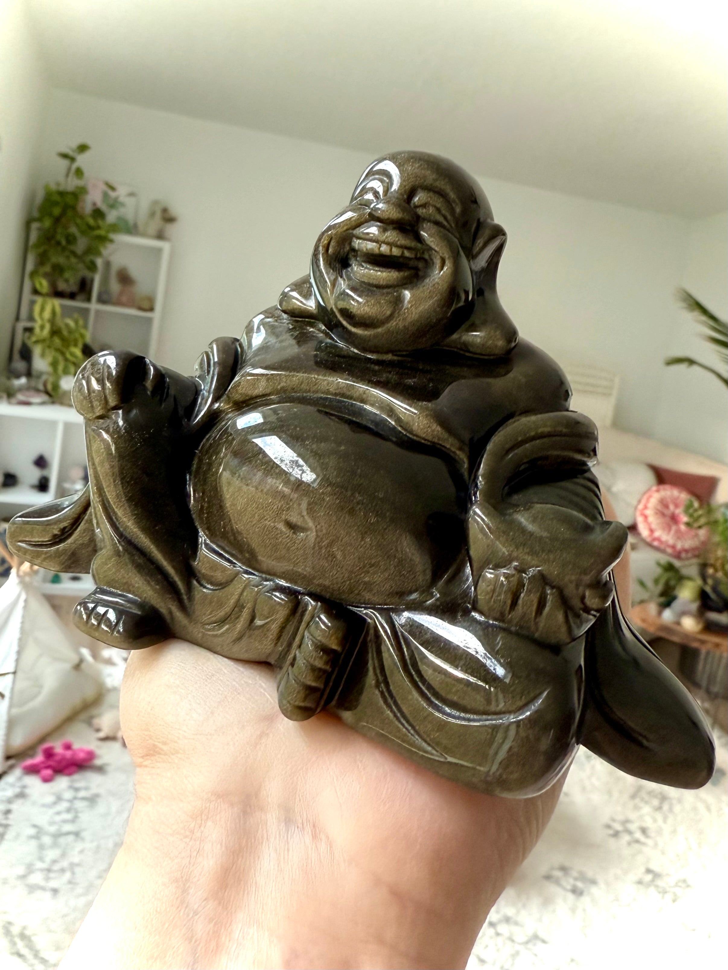 Golden Sheen Obsidian Buddha carving in hand, showing gold flash and joyful energy, healing crystal statue for luck and happiness