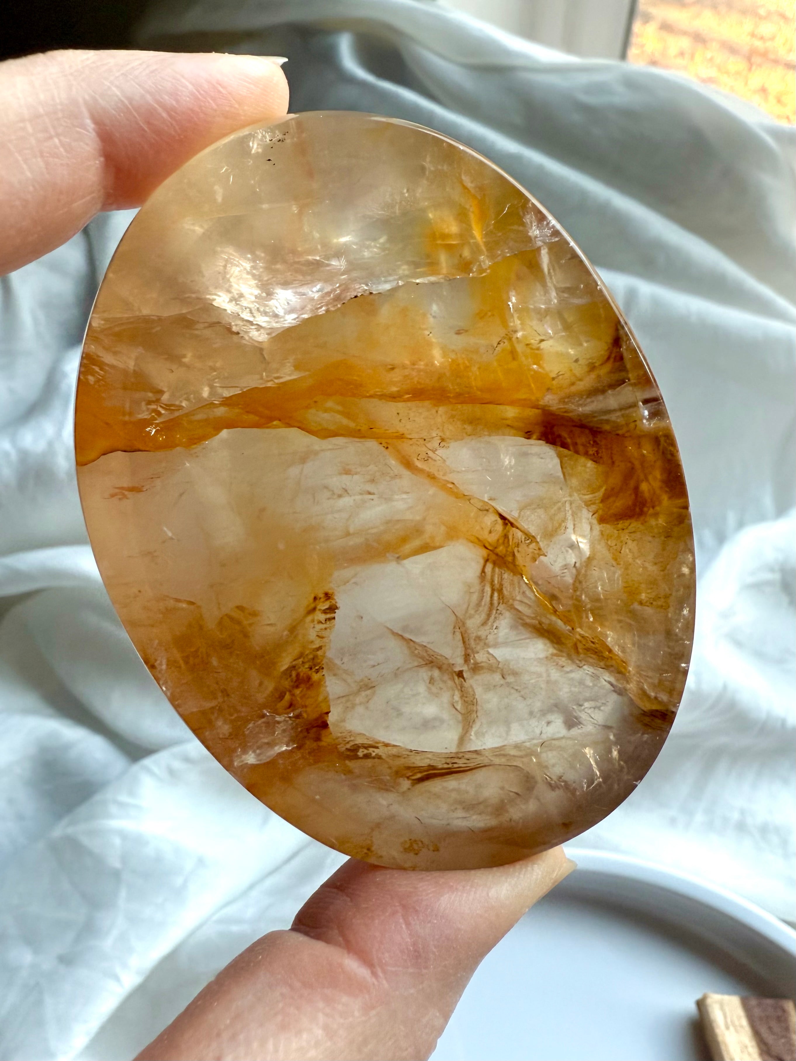 Closeup of a small Golden Healer Quartz bowl in hand showing depth, clarity, and golden hematite inclusions