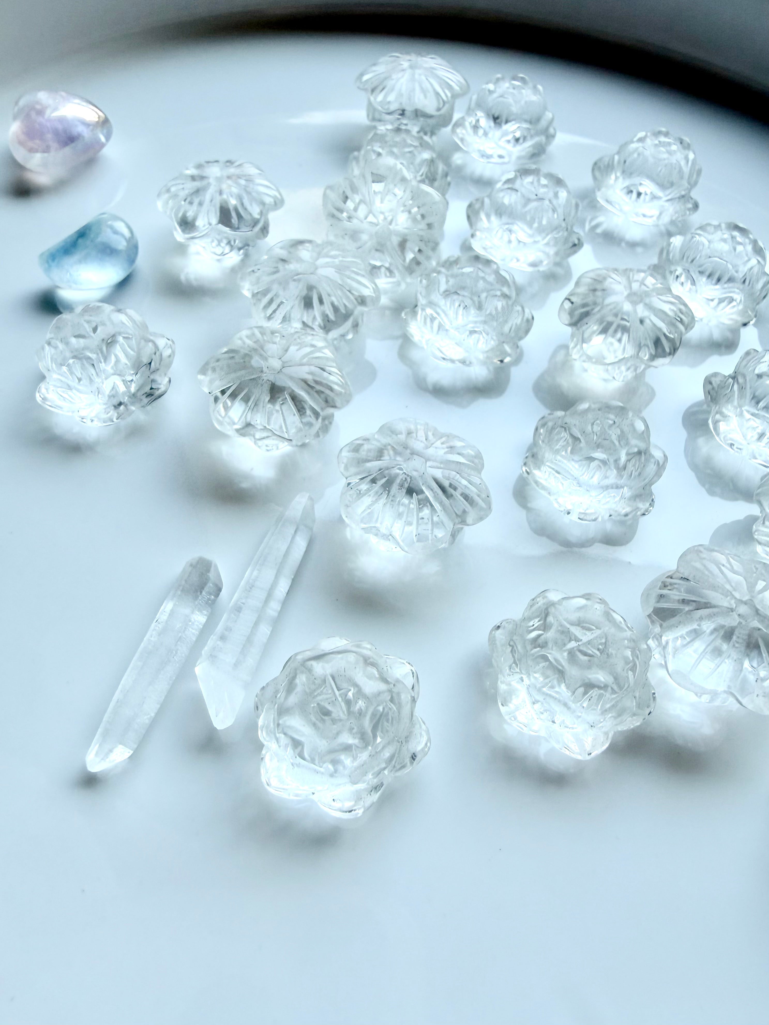 Mini Clear Quartz lotus flower carvings arranged together, small healing crystals for meditation and intention setting