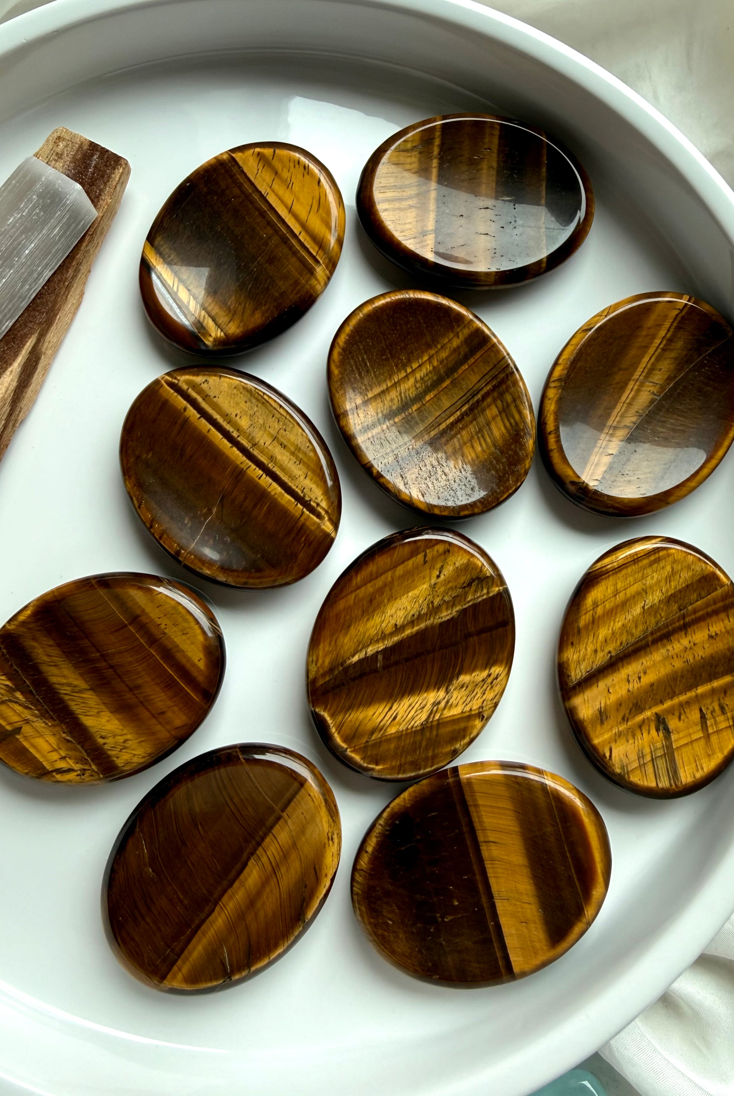 top view of tiger’s eye thumb stones in bowl with rich golden brown tones, worry stones for confidence grounding and focus