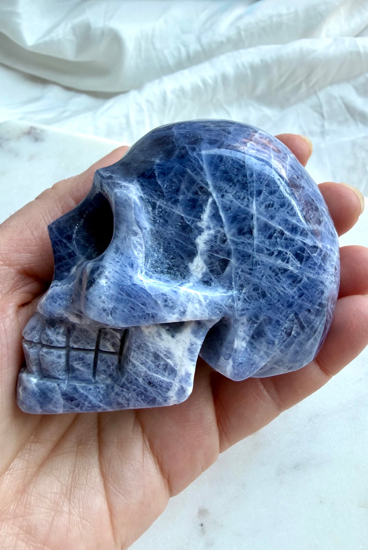 Blue Sodalite skull carving with polished finish and natural white mineral patterning