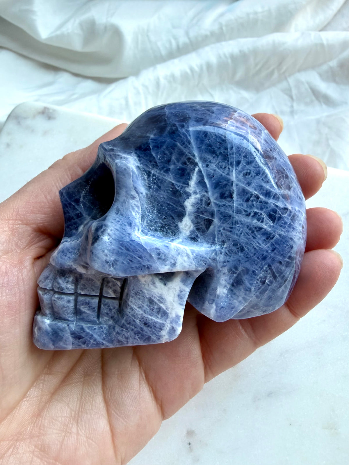 Blue Sodalite skull carving with polished finish and natural white mineral patterning
