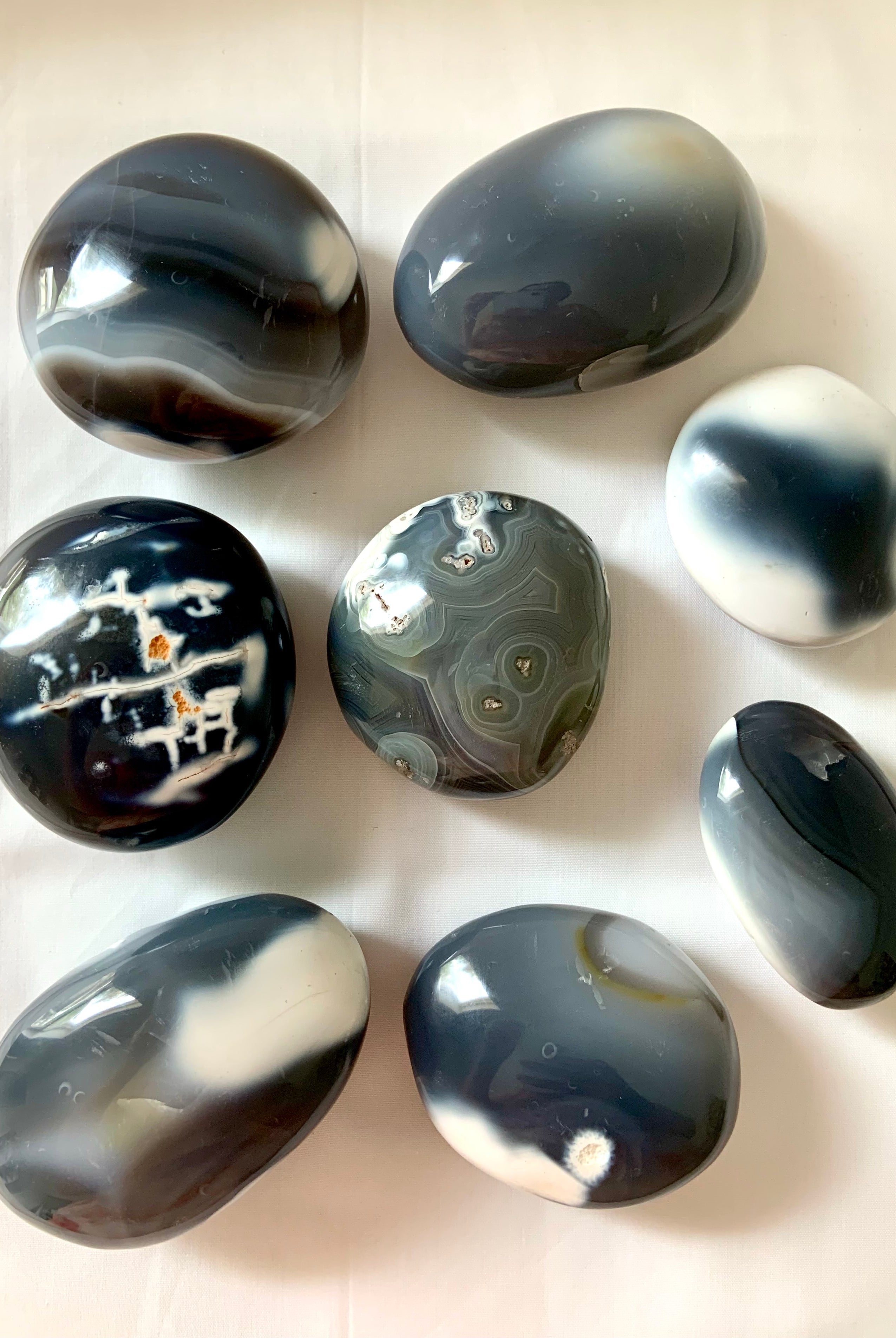 an array of beautiful orca agate palm stones with interesting black, white and gray patterns in the stones, choose your favorite!