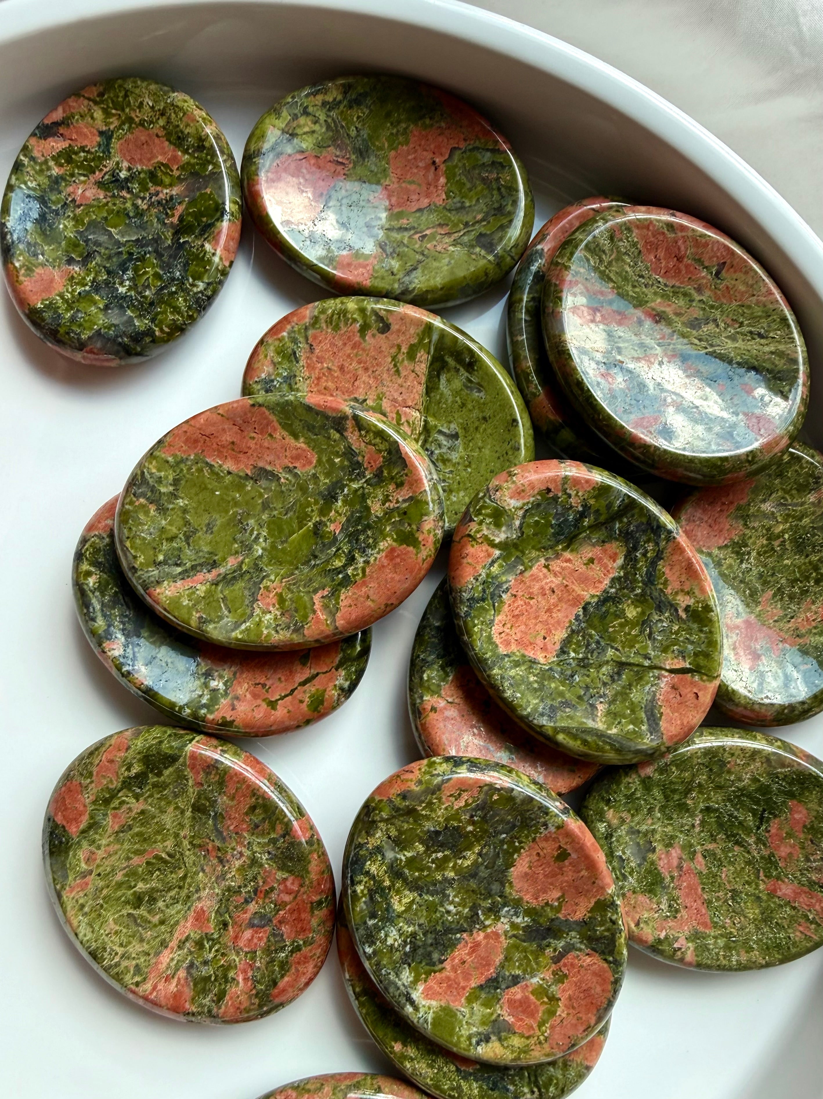 unakite palm stones grouped on plate for meditation heart healing and stability