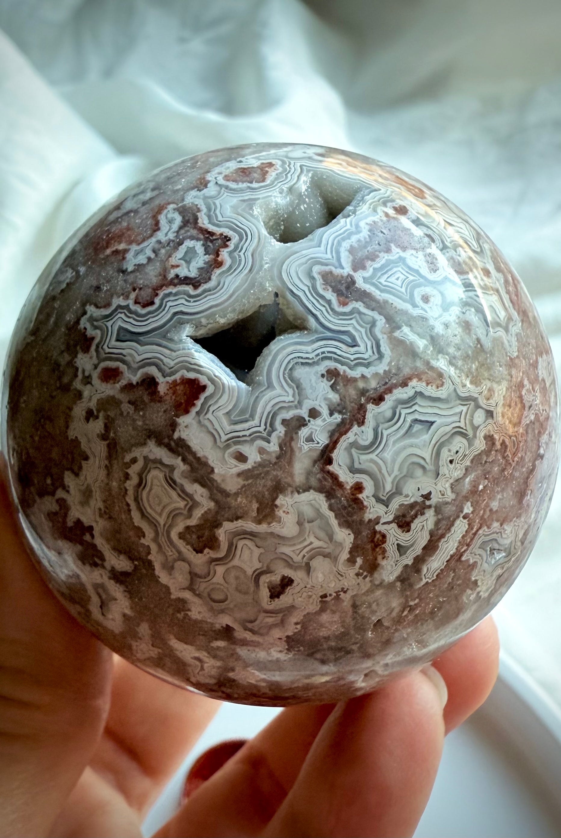 Earthy Crazy Lace Agate sphere with flowing patterns in red, gray, and white agate for energetic alignment