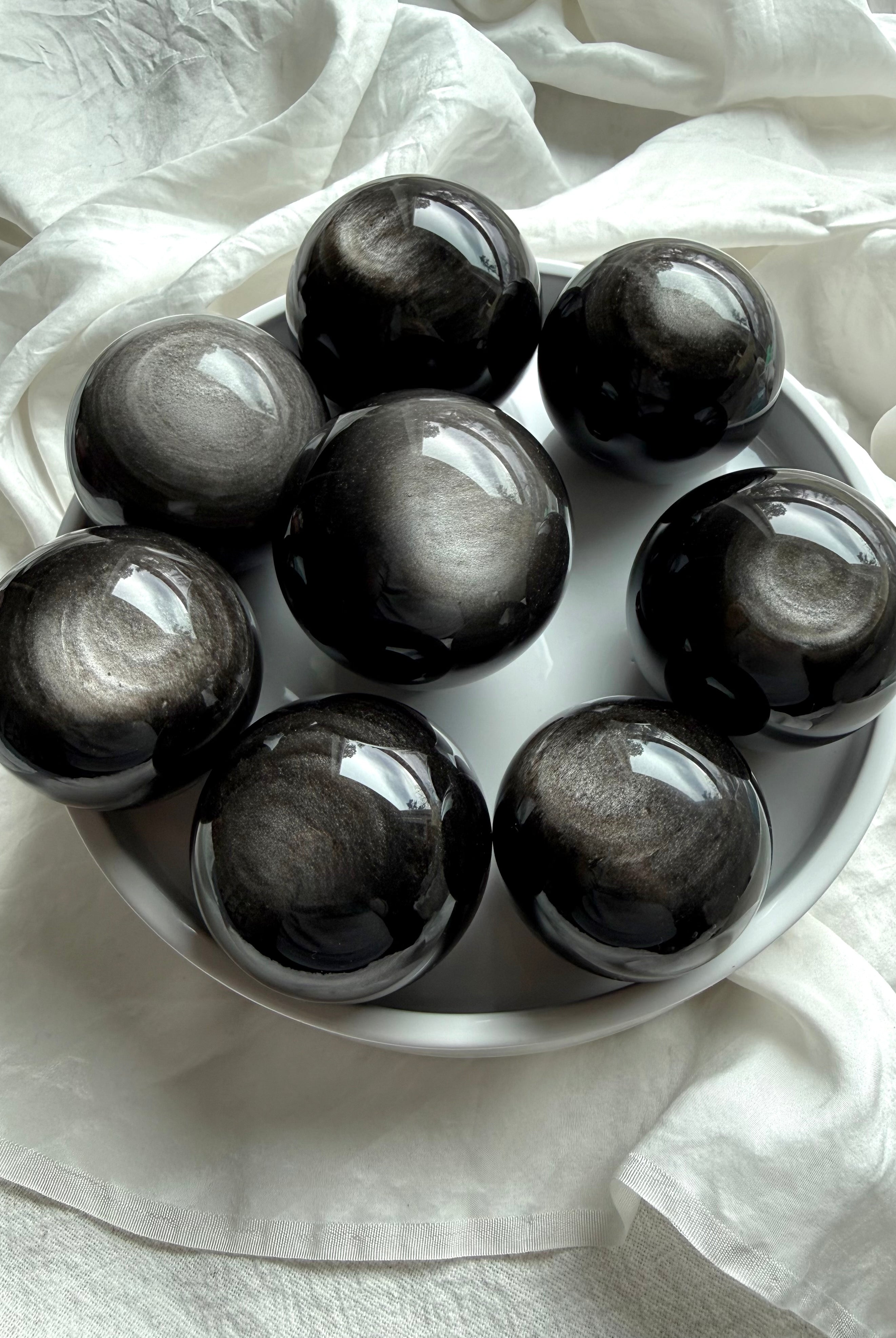 Silver Sheen Obsidian spheres displaying swirling silver flash — polished obsidian crystal balls for energy protection and insight