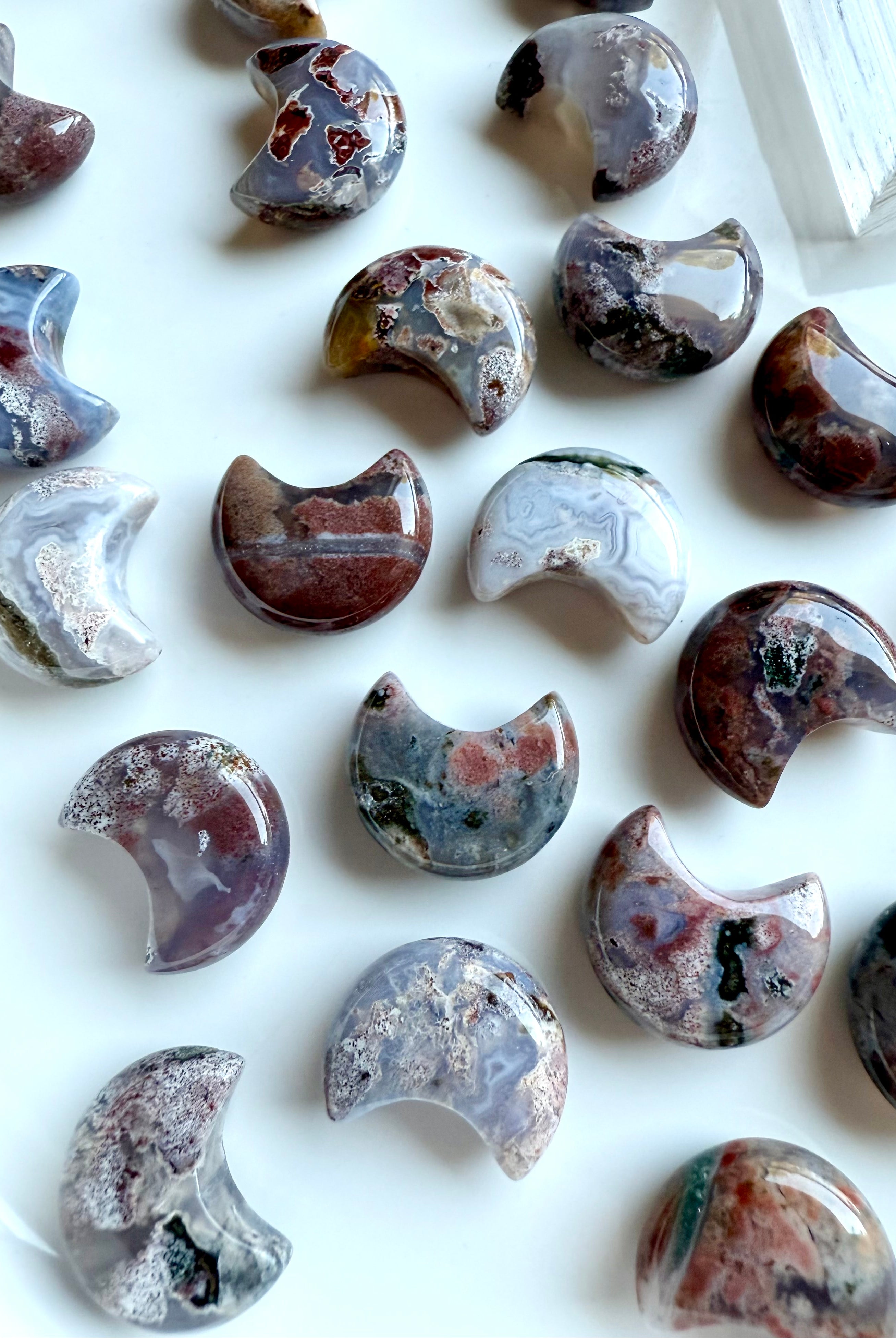 Group of mini Ocean Jasper crescent moon carvings, polished with swirling colors