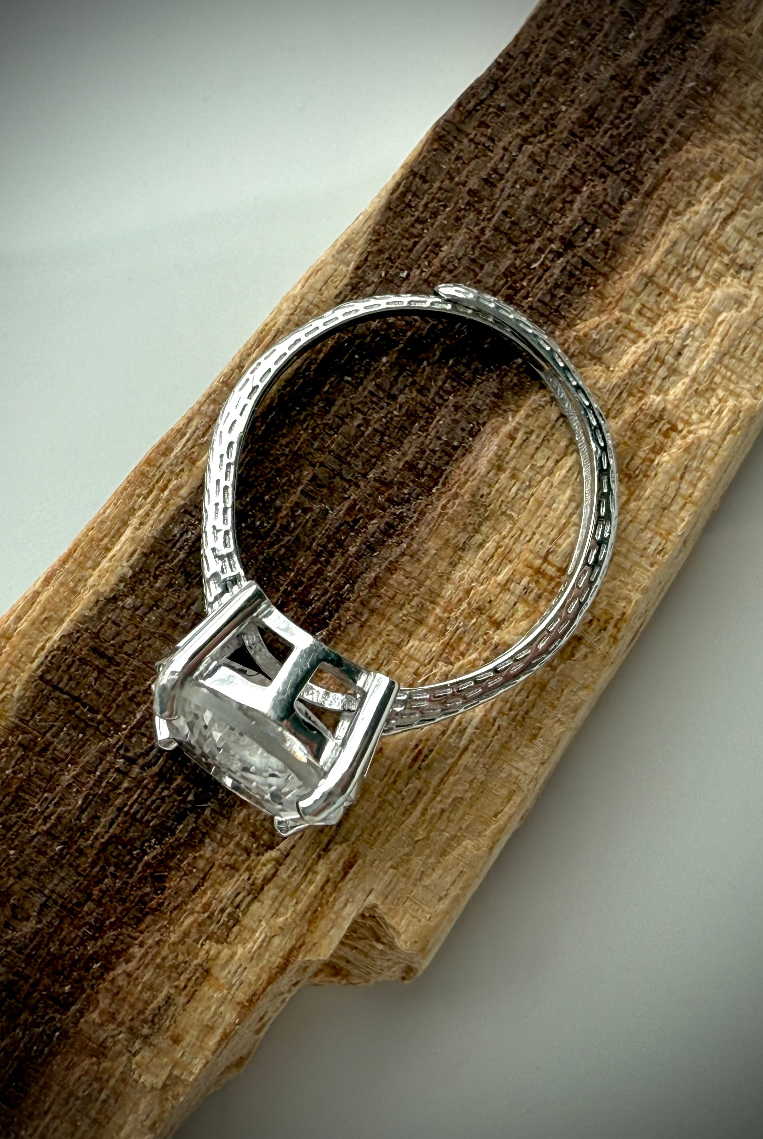 side view of sterling silver moon ring showing details of adjustable band design on wooden surface