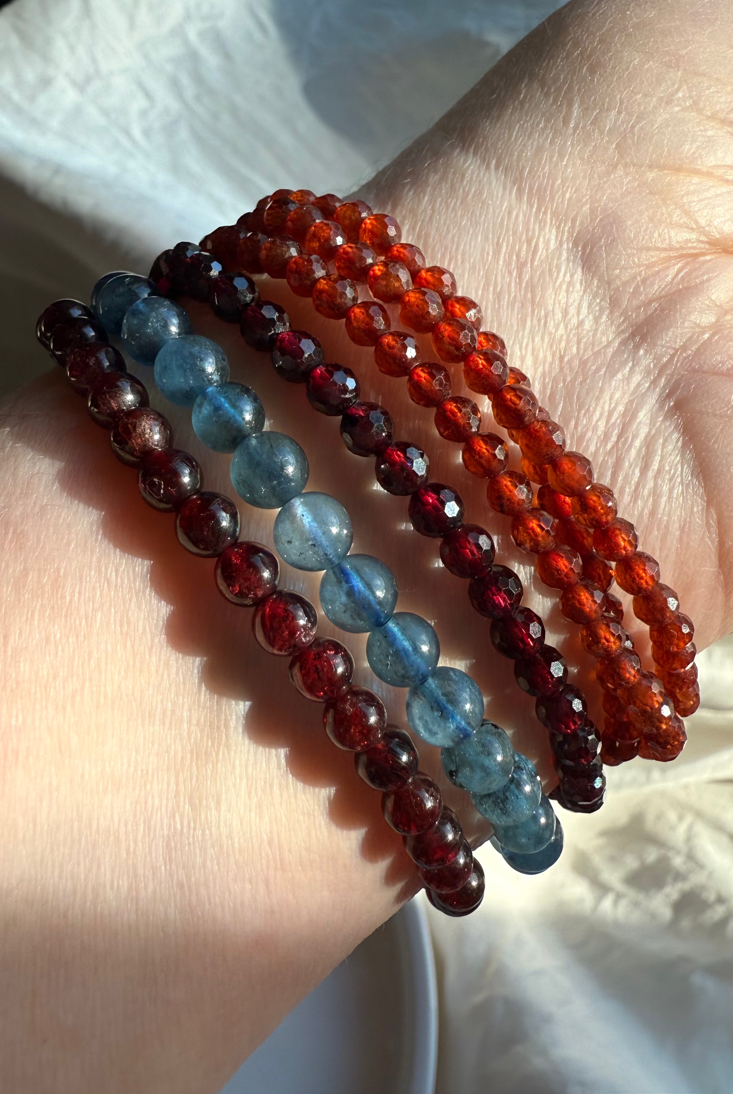 Our Faceted Spessartite Garnet Wrap Bracelet shown with Almandine Garnet + Aquamarine bracelets