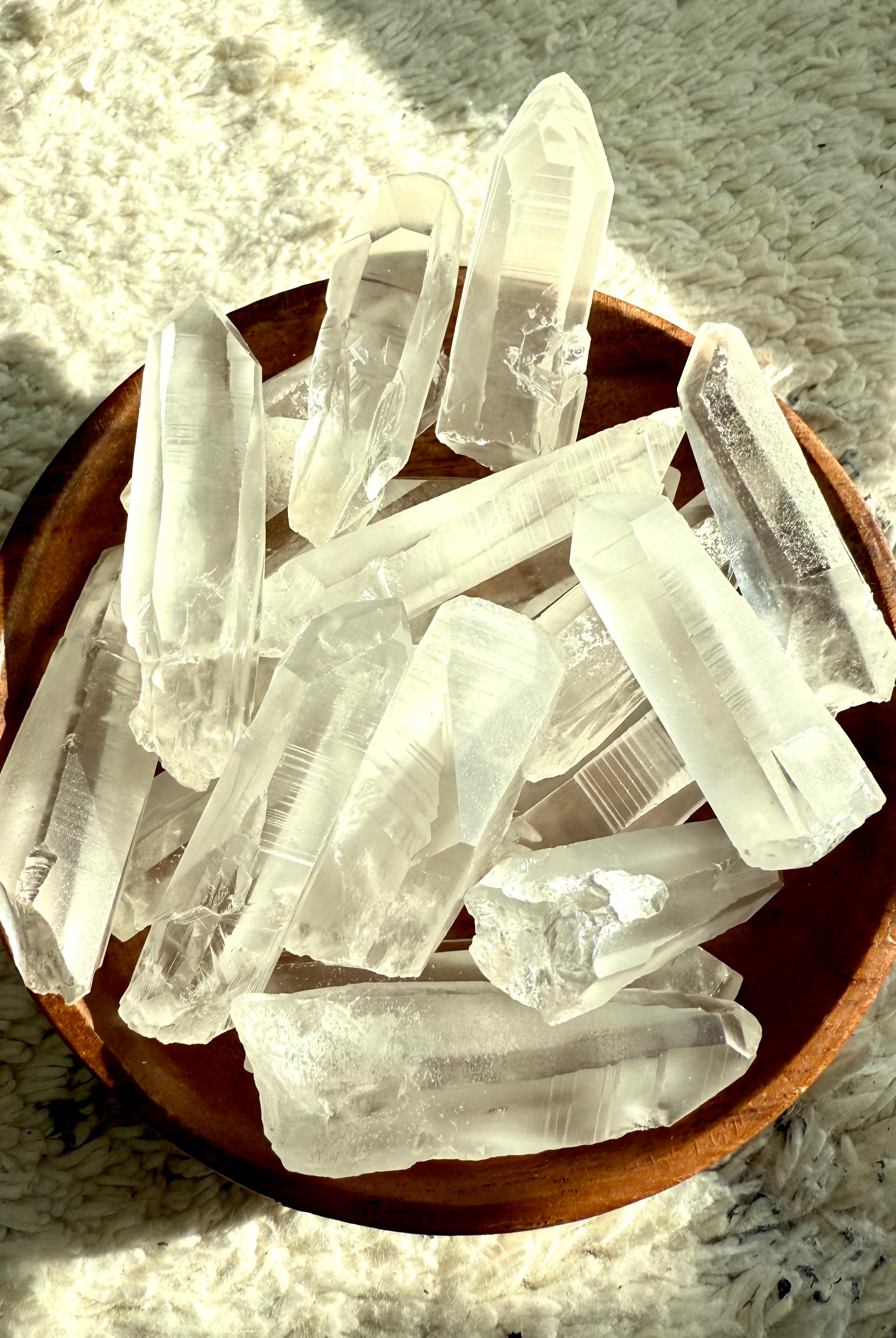 Assorted Lemurian Quartz Points in a wooden bowl — authentic Brazilian crystals for spiritual connection, aura cleansing & meditation.