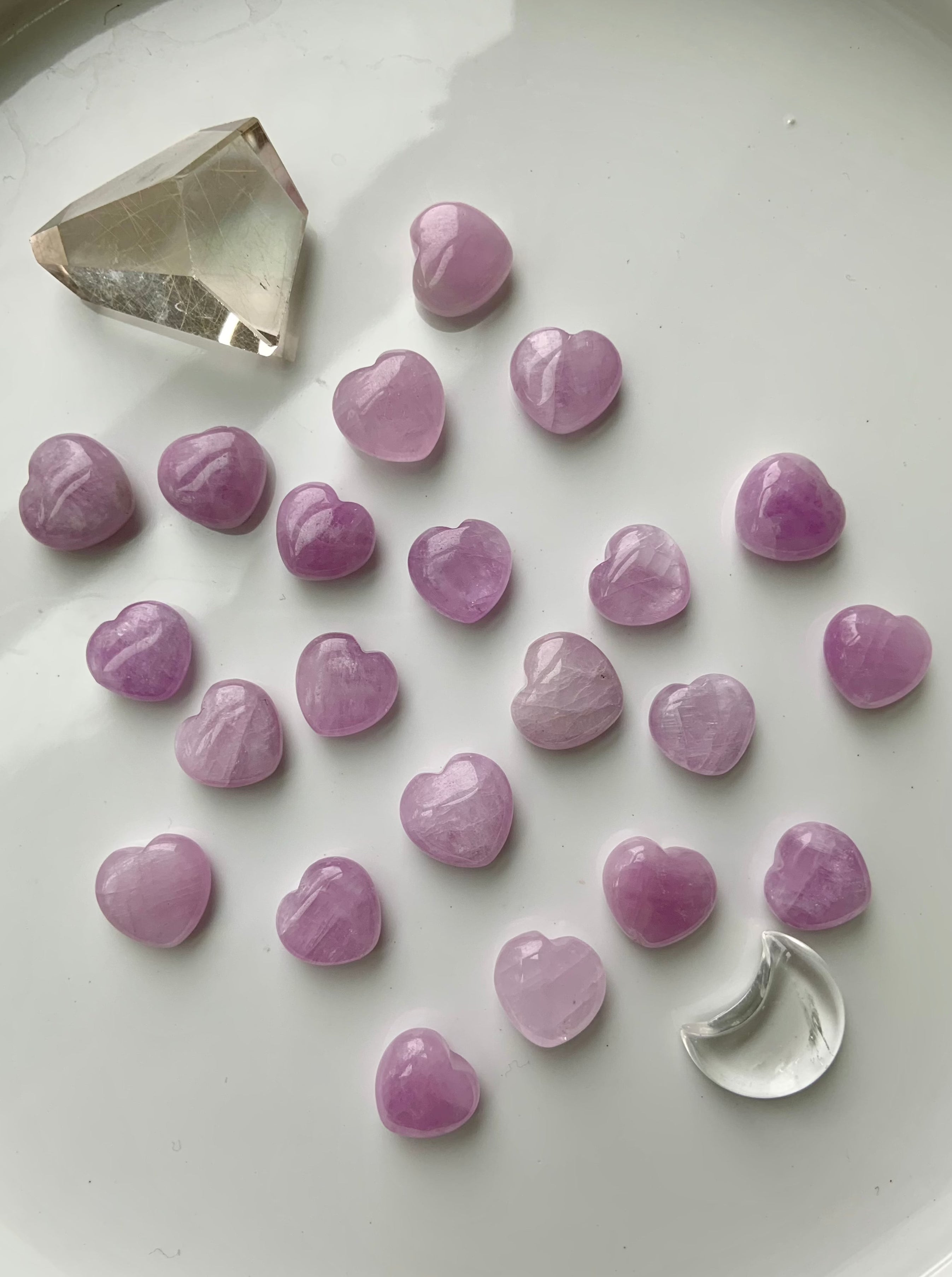 Wide shot of Pink Kunzite mini hearts with other crystals on a white background — soft pink crystal hearts for love, calm & intentional energy work.