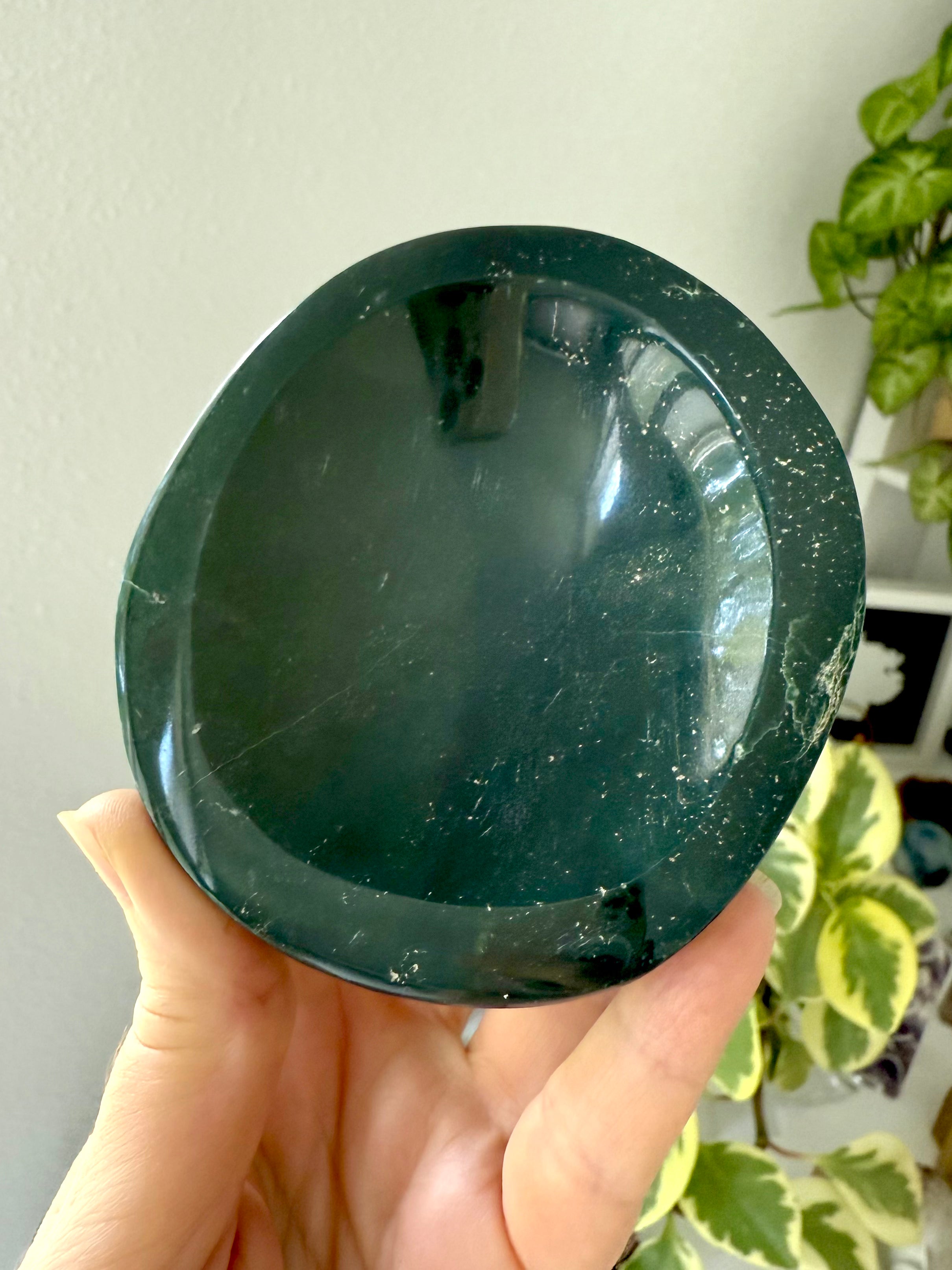 A hand carved teal green Ocean Jasper Bowl held in a hand for scale. Display your treasures in style