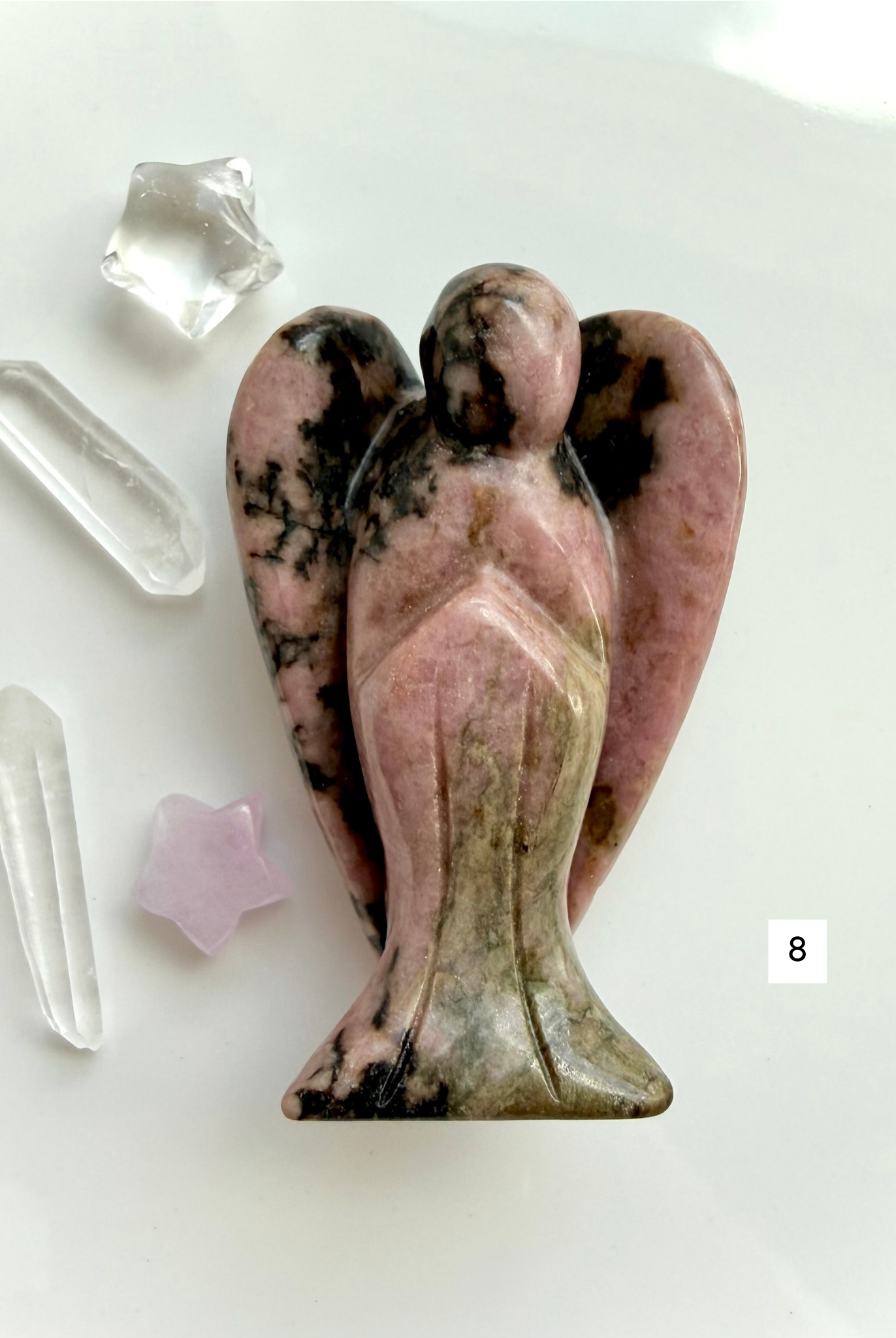 Rhodonite angel carving with deep rose coloring and polished finish for compassion and healing