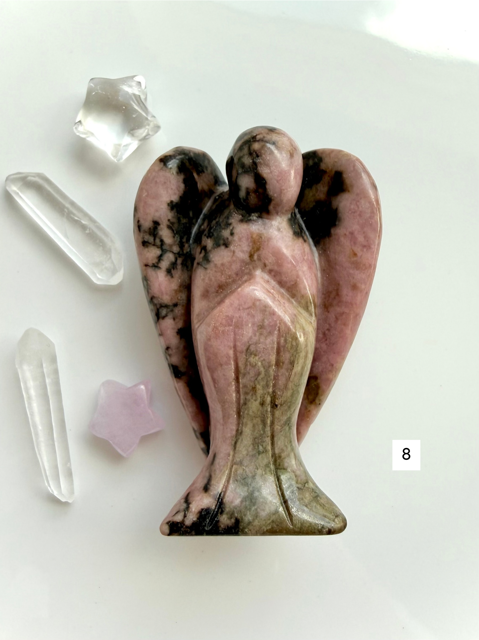 Rhodonite angel carving with deep rose coloring and polished finish for compassion and healing