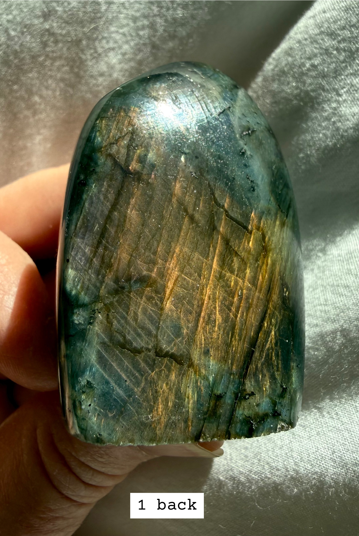 Back side of labradorite freeform showing peachy rainbow flash.