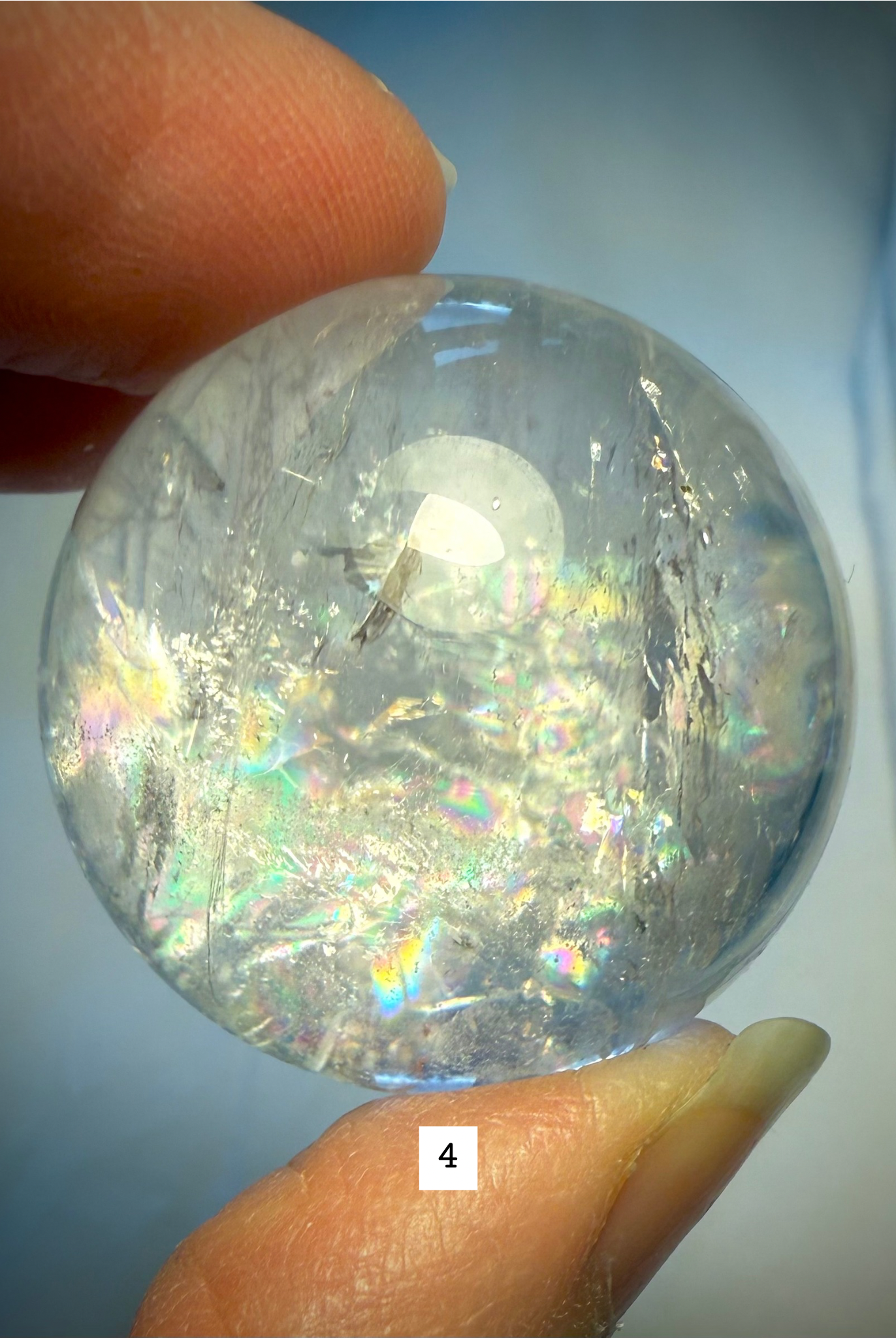 Rainbow Quartz sphere #4 featuring subtle rainbows, veils, and clear quartz transparency in bright light.