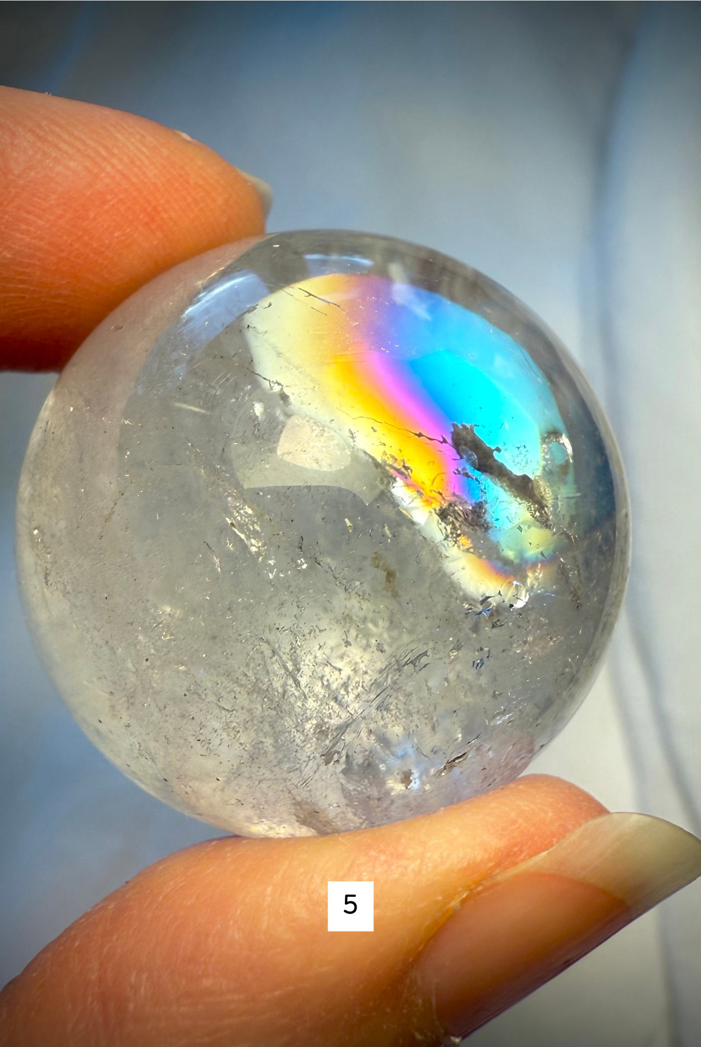 Crystal ball #5 with prismatic rainbows and icy inclusions, showcasing the beauty of Rainbow Quartz up close.
